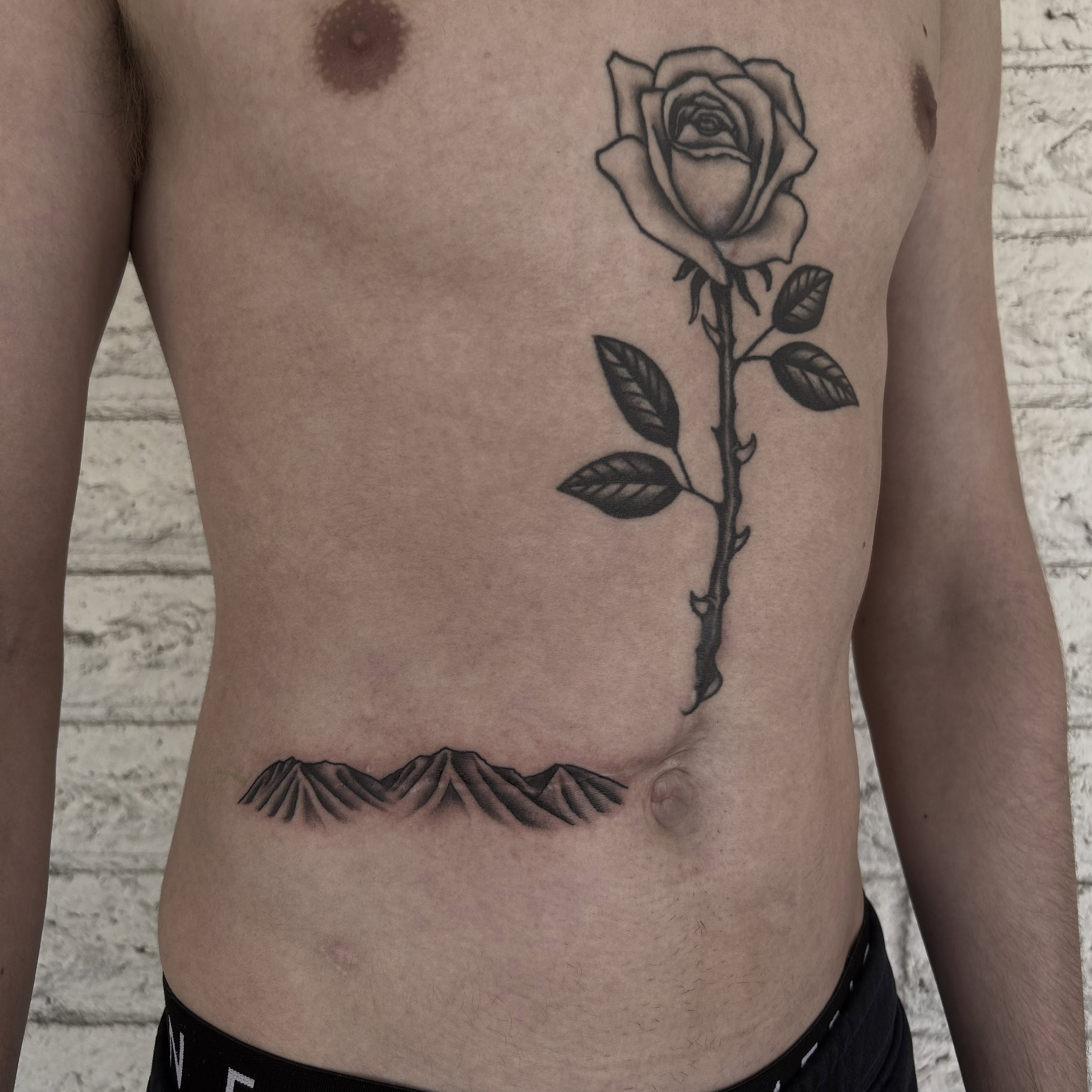 Rose black and grey tattoo on the ribs by Stephen Sanchez