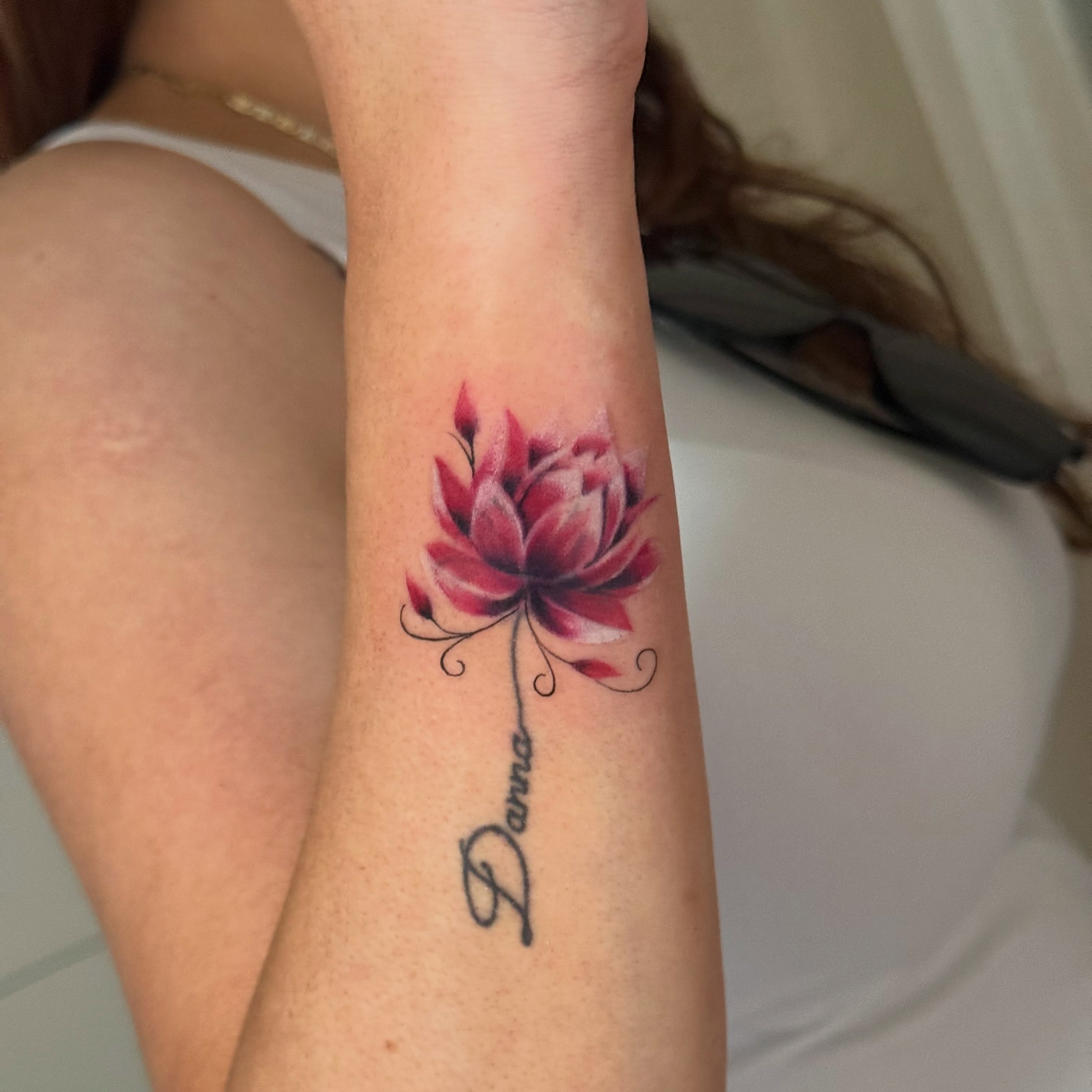 Lotus flower watercolor tattoo on the forearm by Faith Lopez