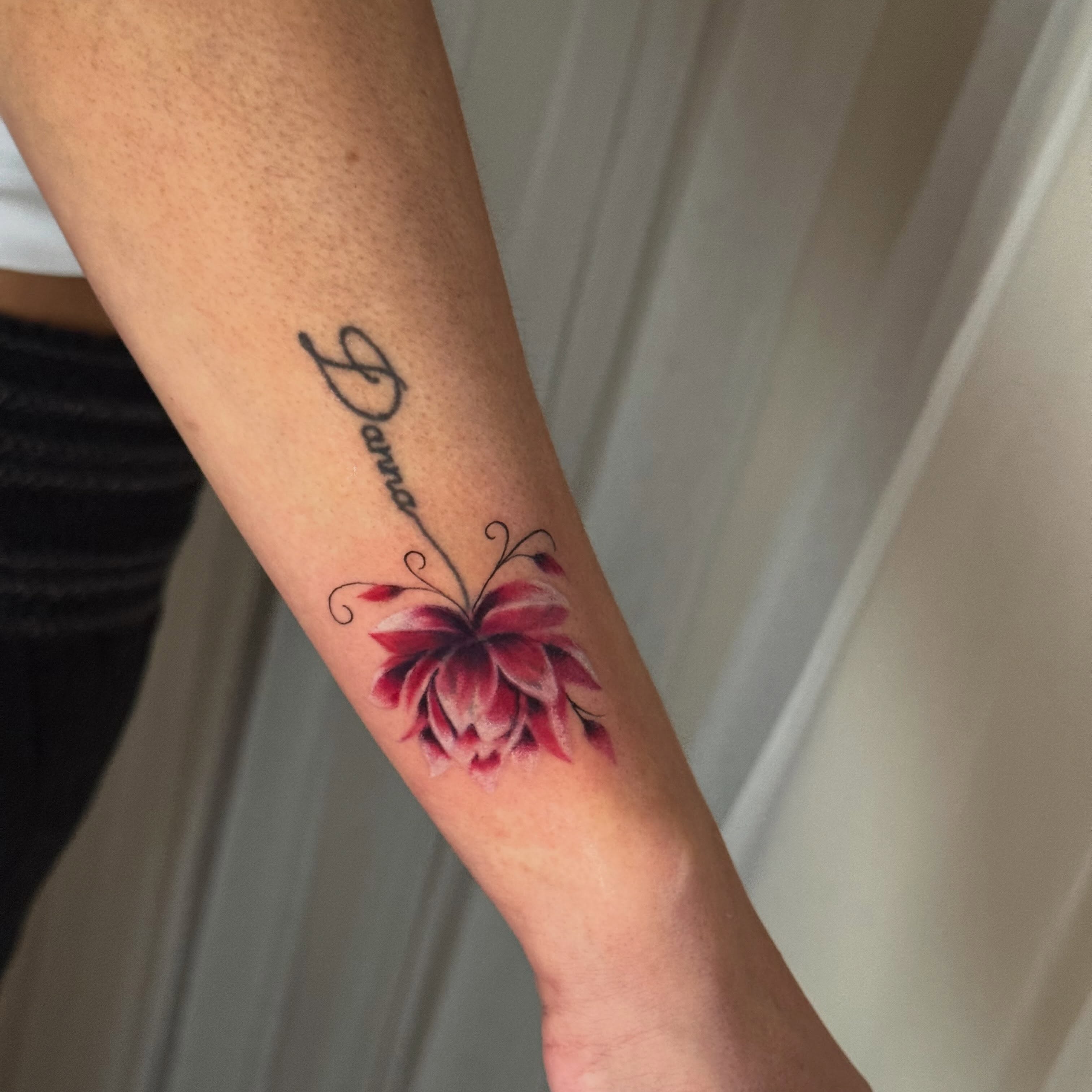 Flower and name realism tattoo on the forearm by Faith Lopez