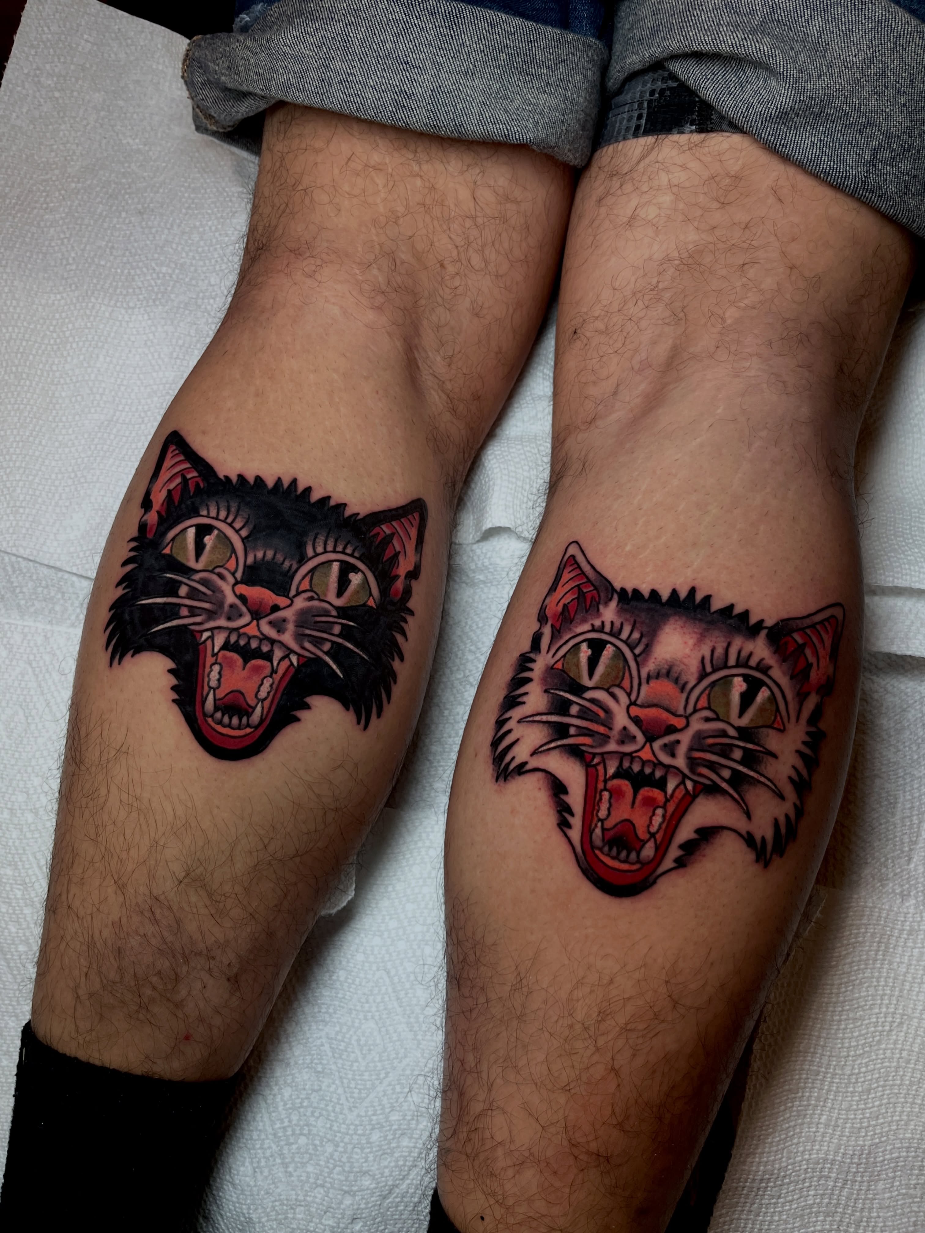 Angry cat heads American traditional tattoo on the leg by Kehrmie Tattoos, Berkeley, California