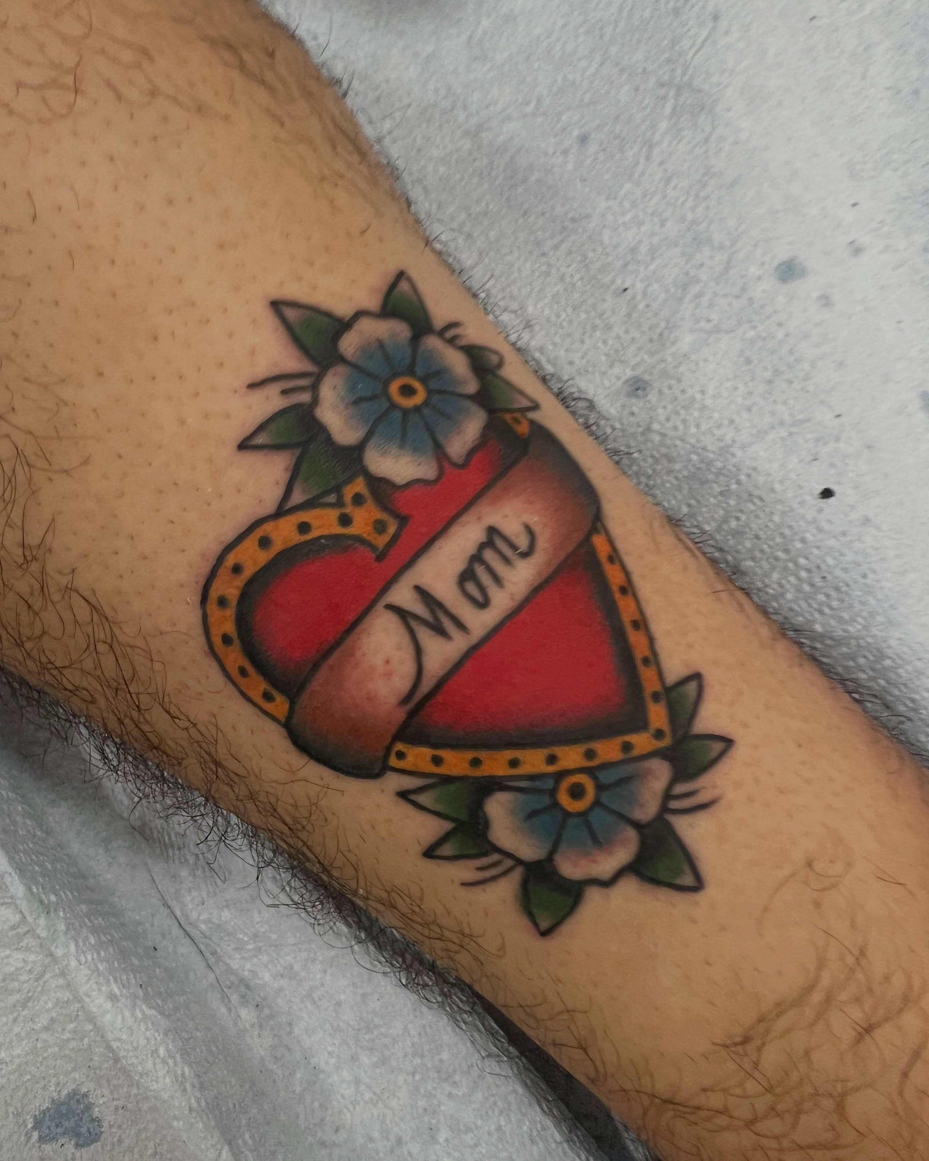 Heart with floral decoration American traditional tattoo on the forearm by Samantha Citer