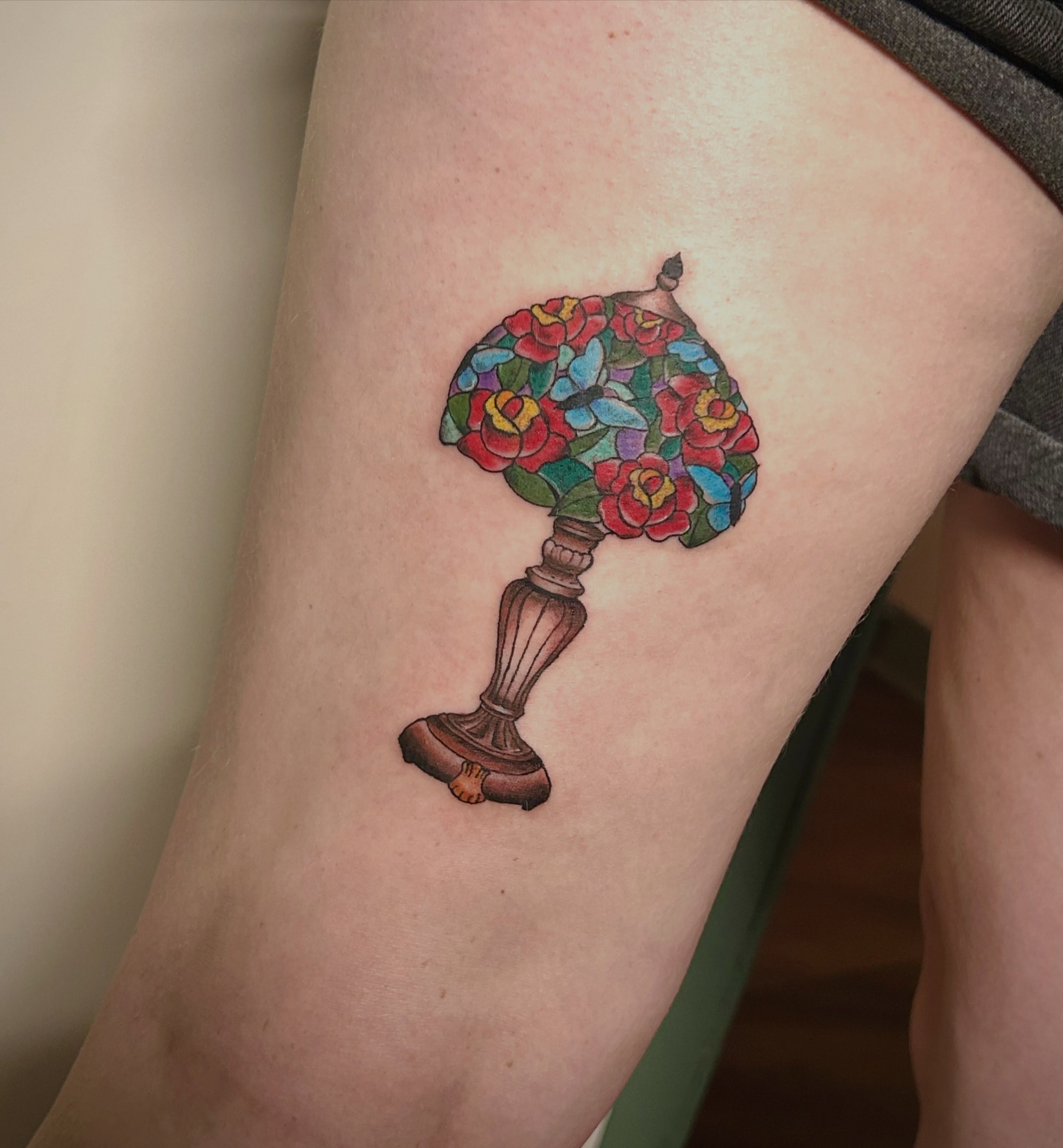 Stained glass lamp illustrative tattoo on the forearm by Miss Katie