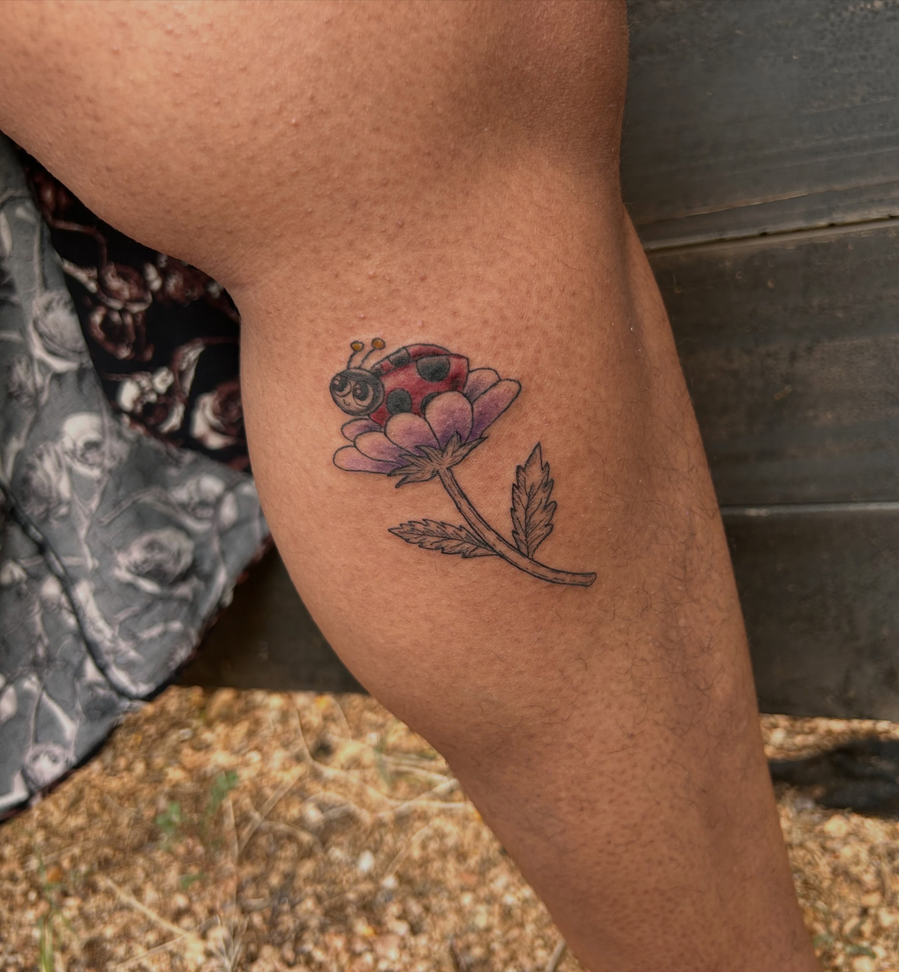 Ladybug and flower dotwork tattoo on the thigh by Miss Katie