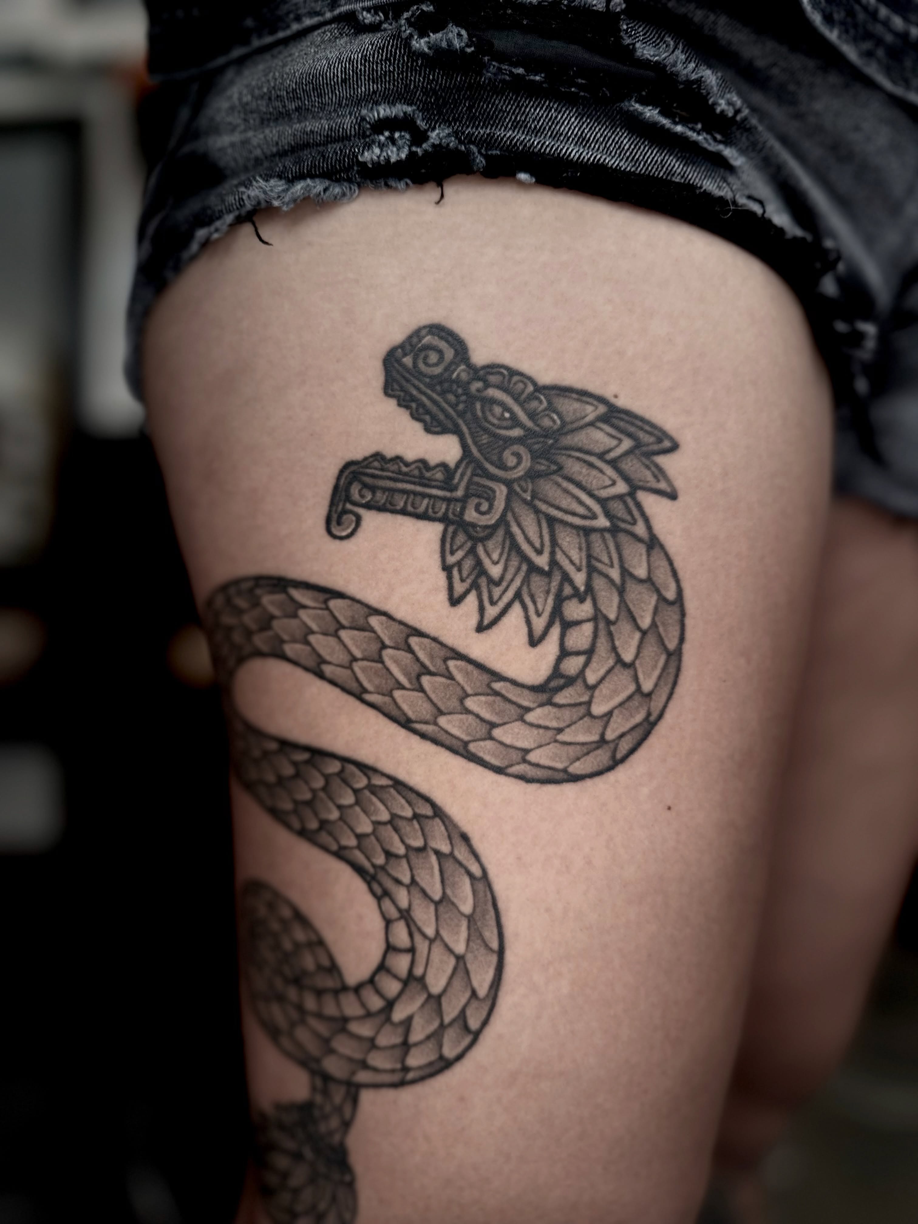 Snake black and grey tattoo on the thigh by Barbara Gonzalez
