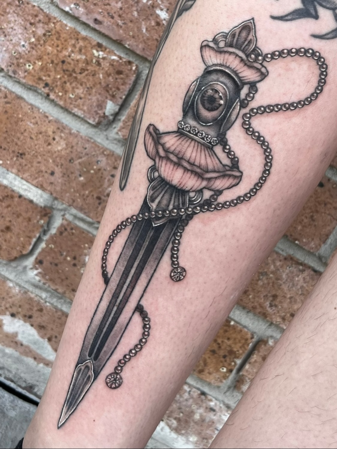 Knife with ornate handle black and grey tattoo on the forearm by Myla Jane, Houston, Texas