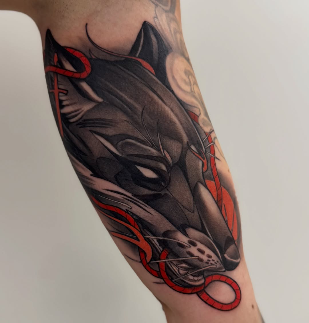 Wolf and snake dark realism tattoo on the forearm by Jaxx Kesler