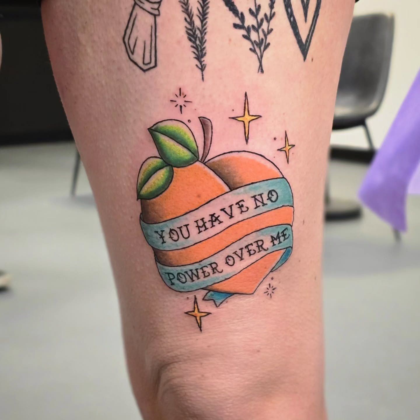 Orange with ribbon American traditional tattoo on the forearm by Anntonietta Borzacchiello