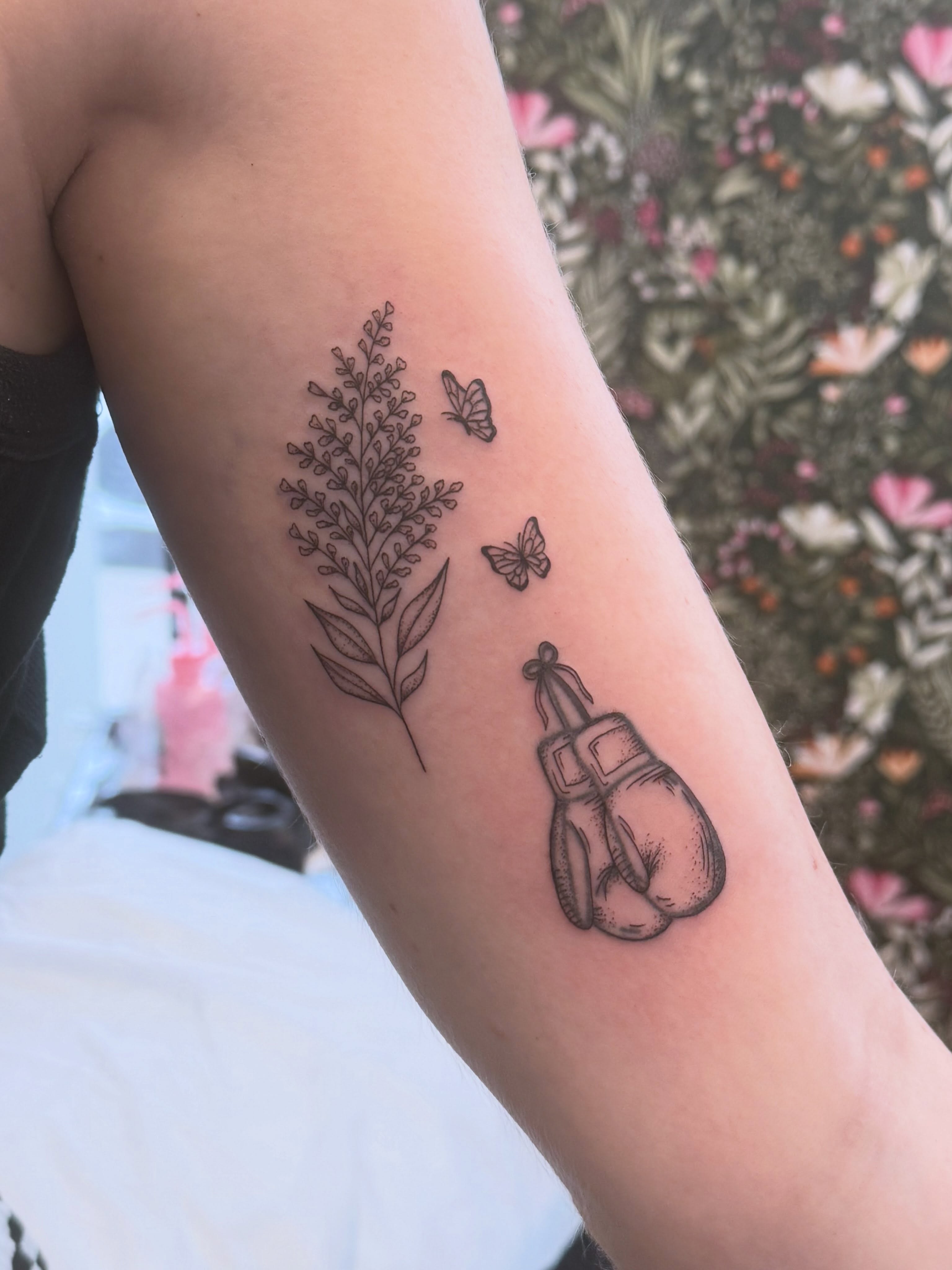 Boxing gloves and plant black and grey tattoo on the forearm by ✨olivia