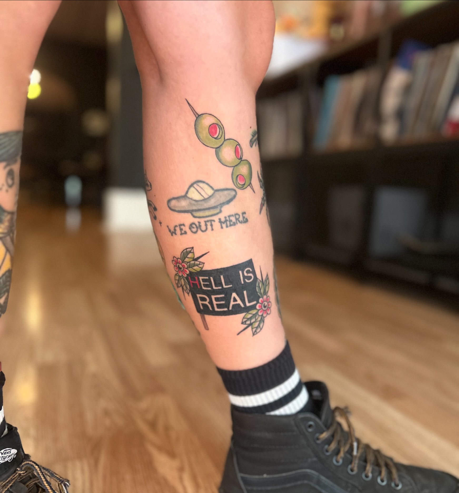 Olives, UFO, text American traditional tattoo on the forearm by Tori Magill