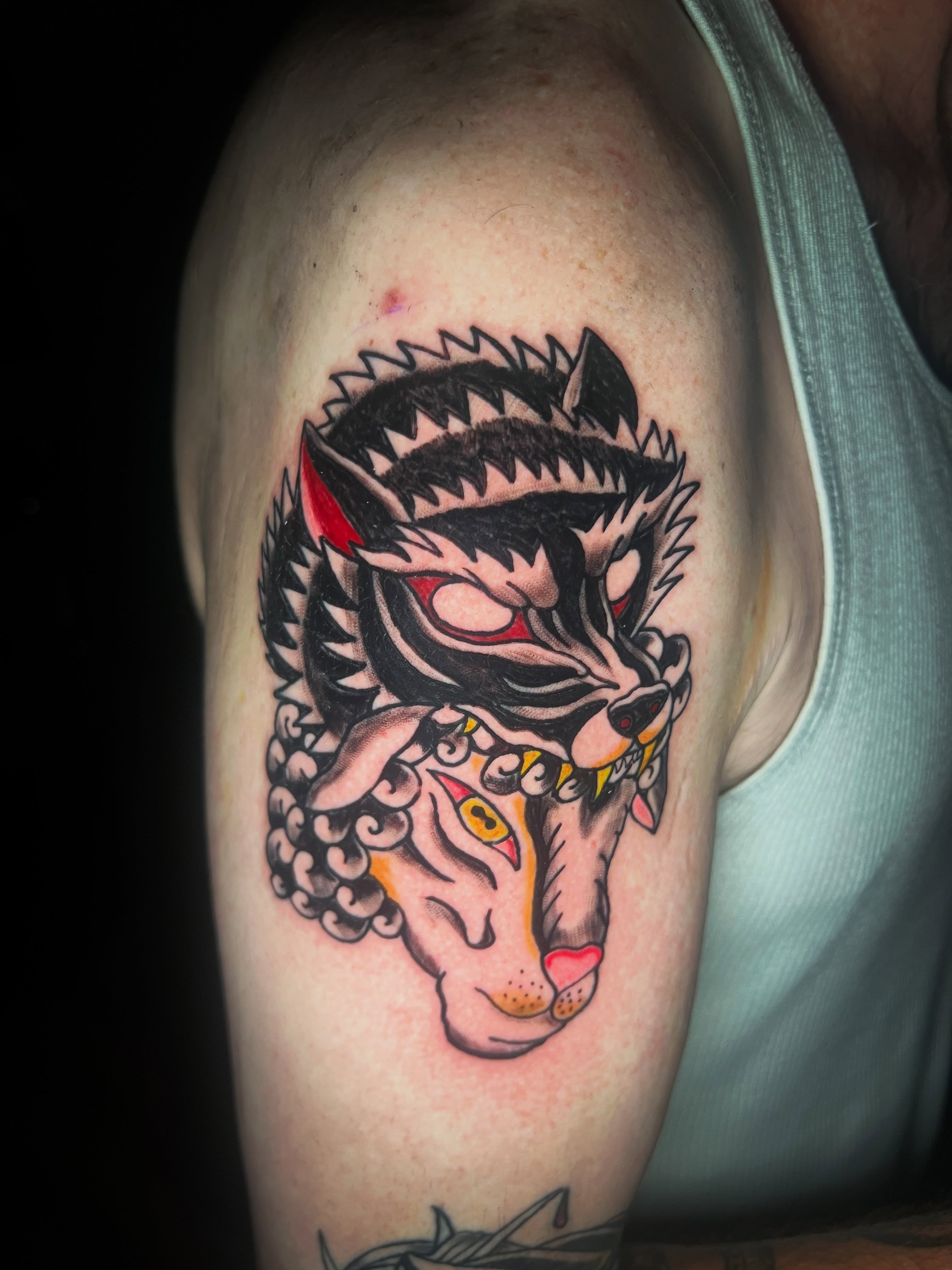 Wolf American traditional tattoo on the shoulder by Evan Intveld