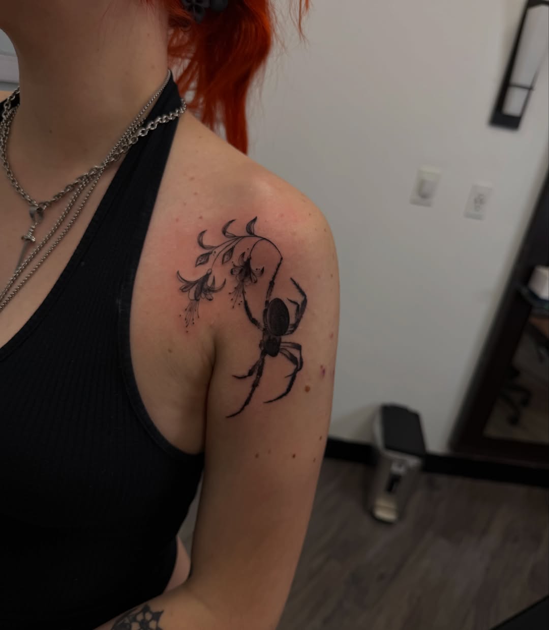 Spider and flower black and grey tattoo on the shoulder by Gladys L.
