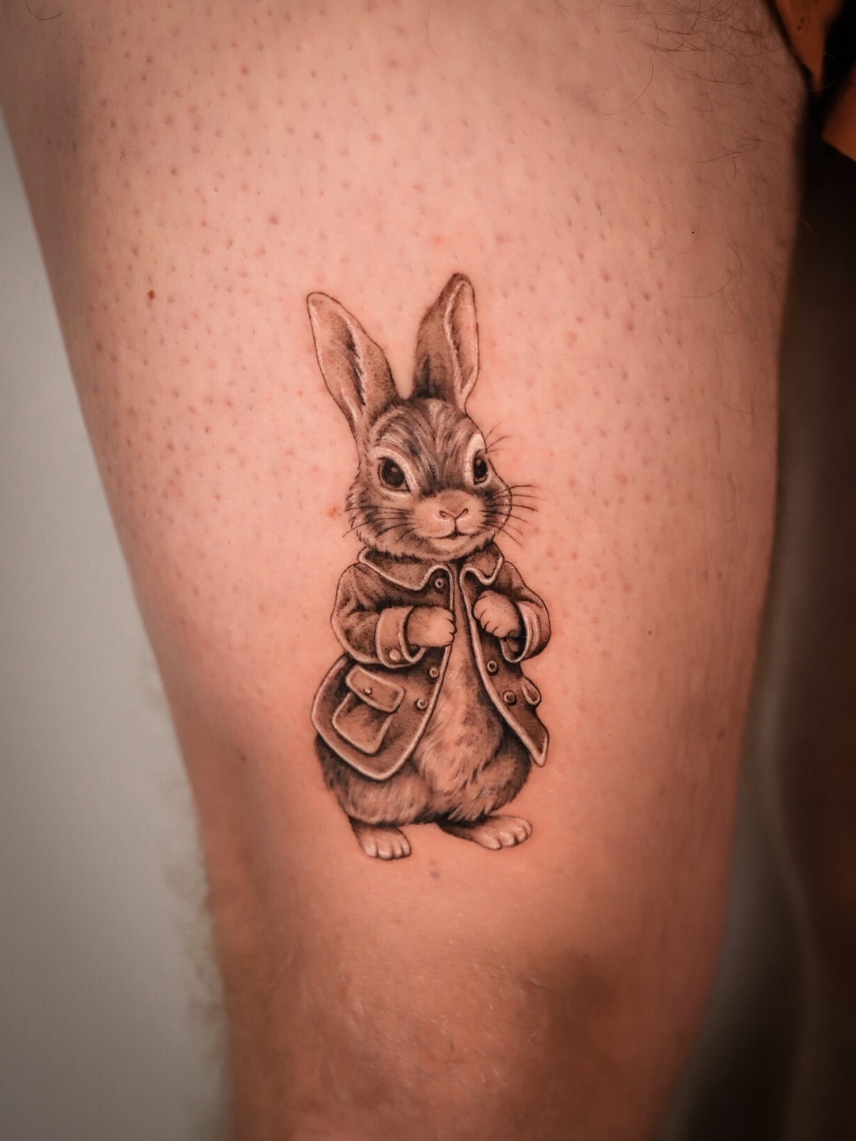 Rabbit in coat realism tattoo on the thigh by Cyn