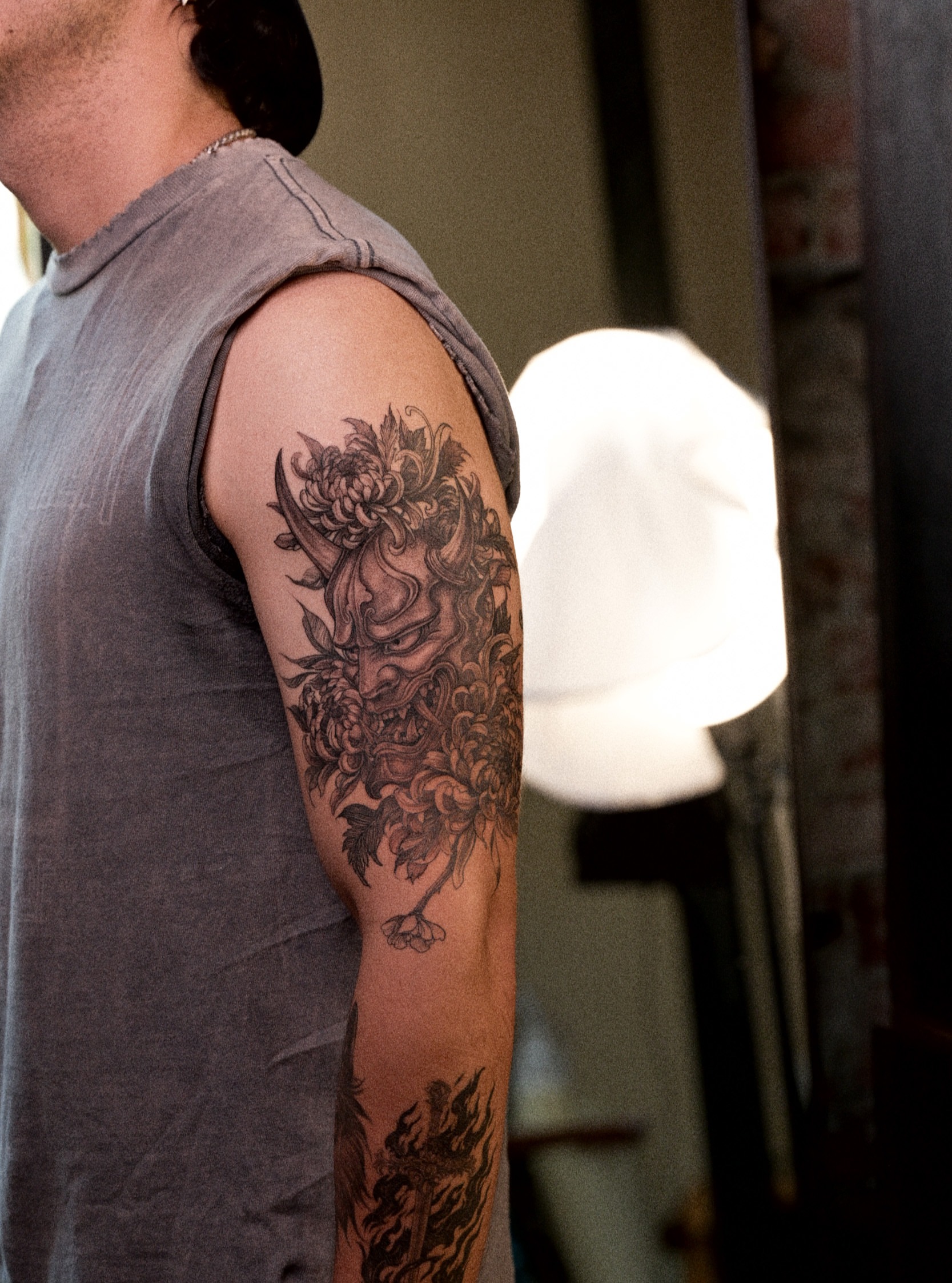 Monster black and grey tattoo on the upper arm by Brad Simmons