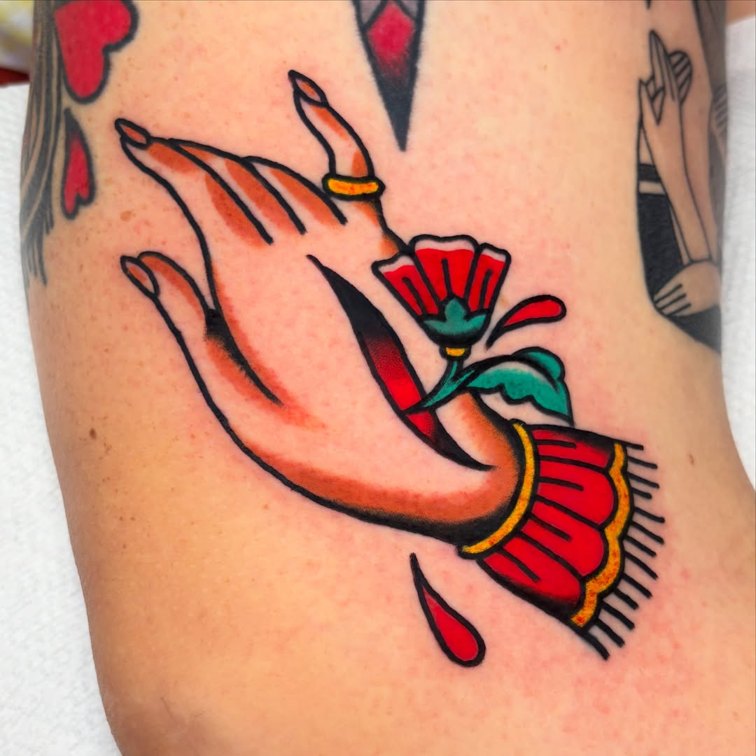 Hand with flower American traditional tattoo on the forearm by Zoe Margot