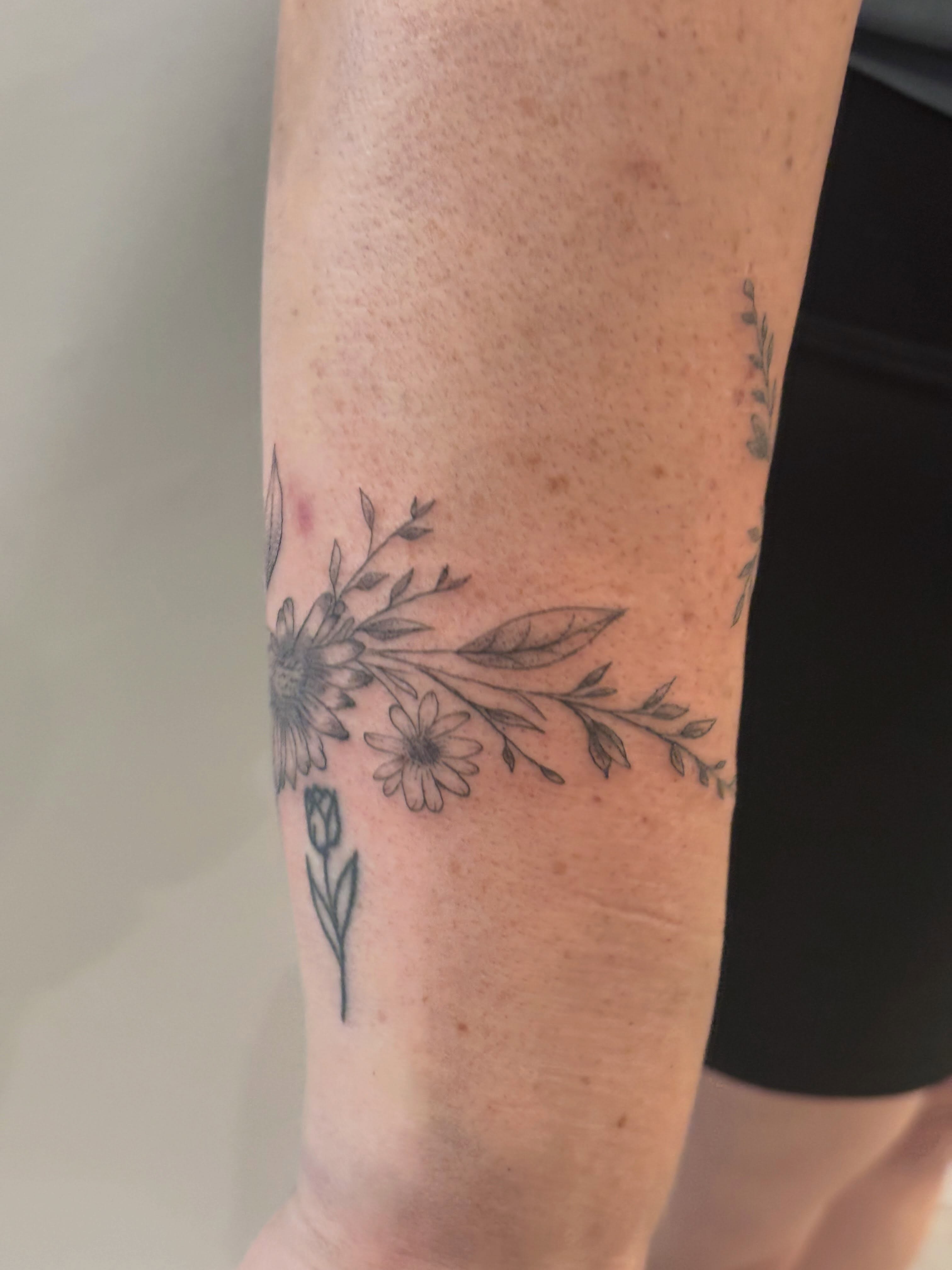 Floral arrangement black and grey tattoo on the forearm by Malissa