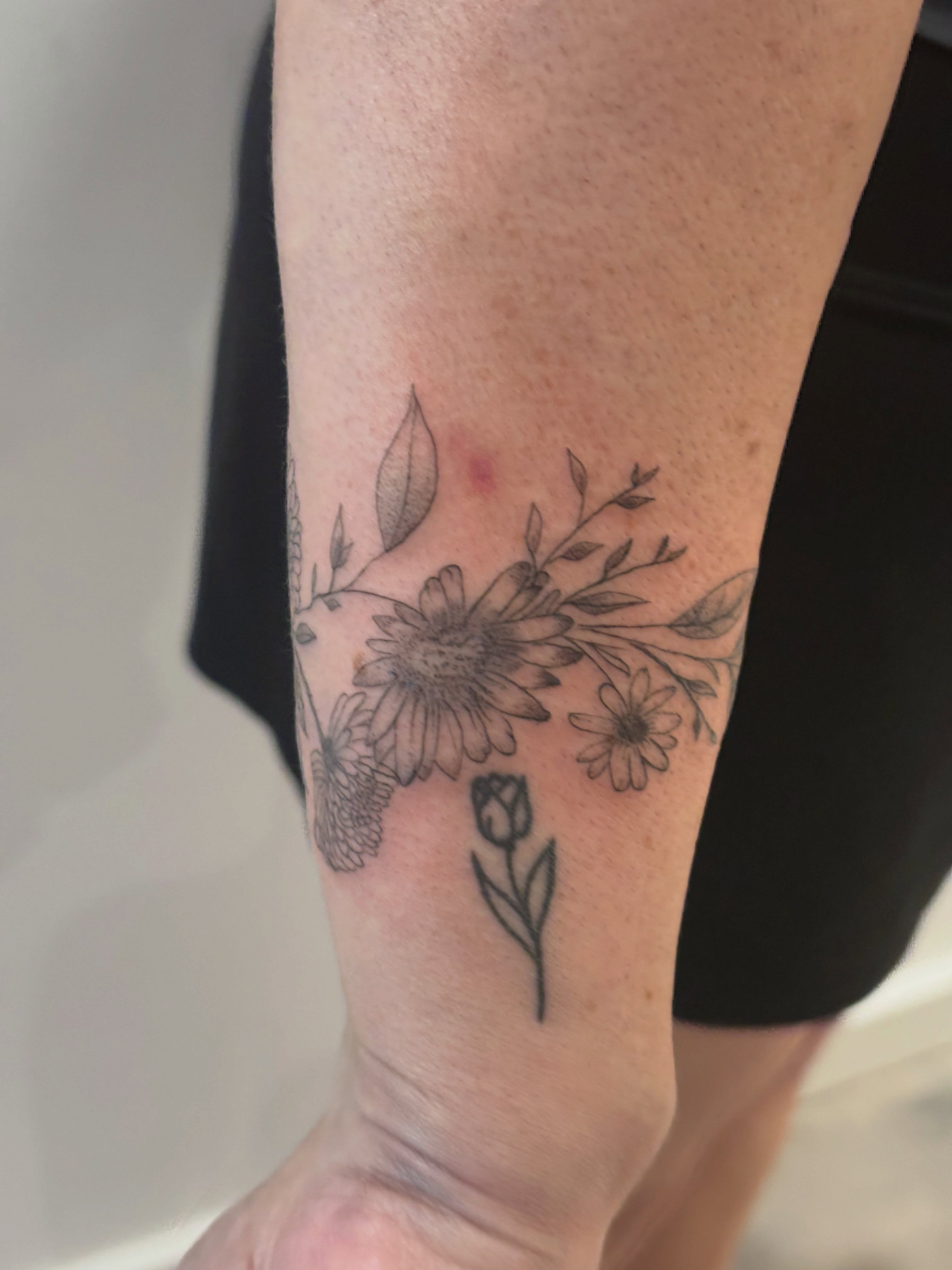 Floral bouquet black and grey tattoo on the forearm by Malissa