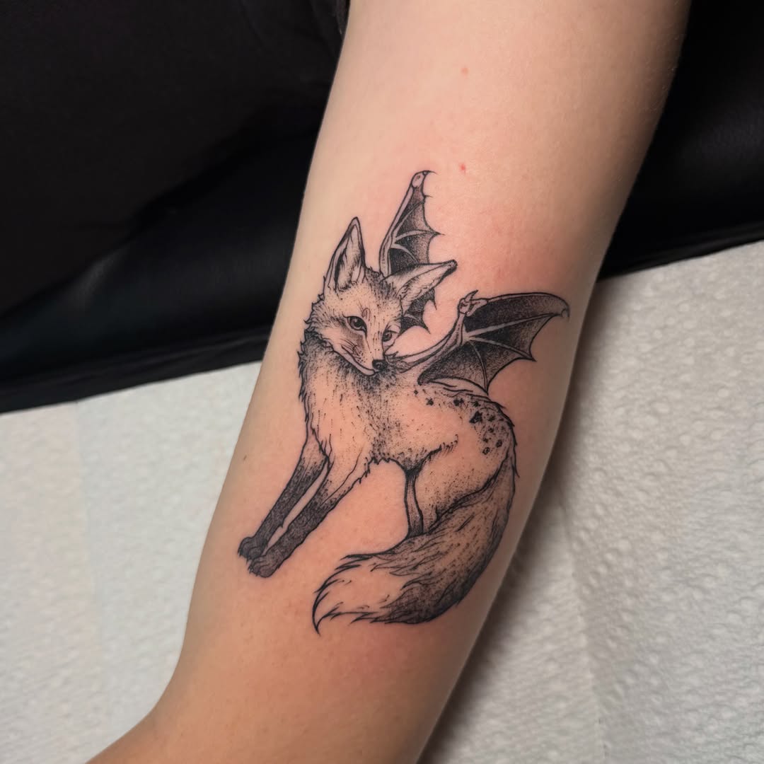 Fox with bat wings dotwork tattoo on the forearm by Lyndze Masters