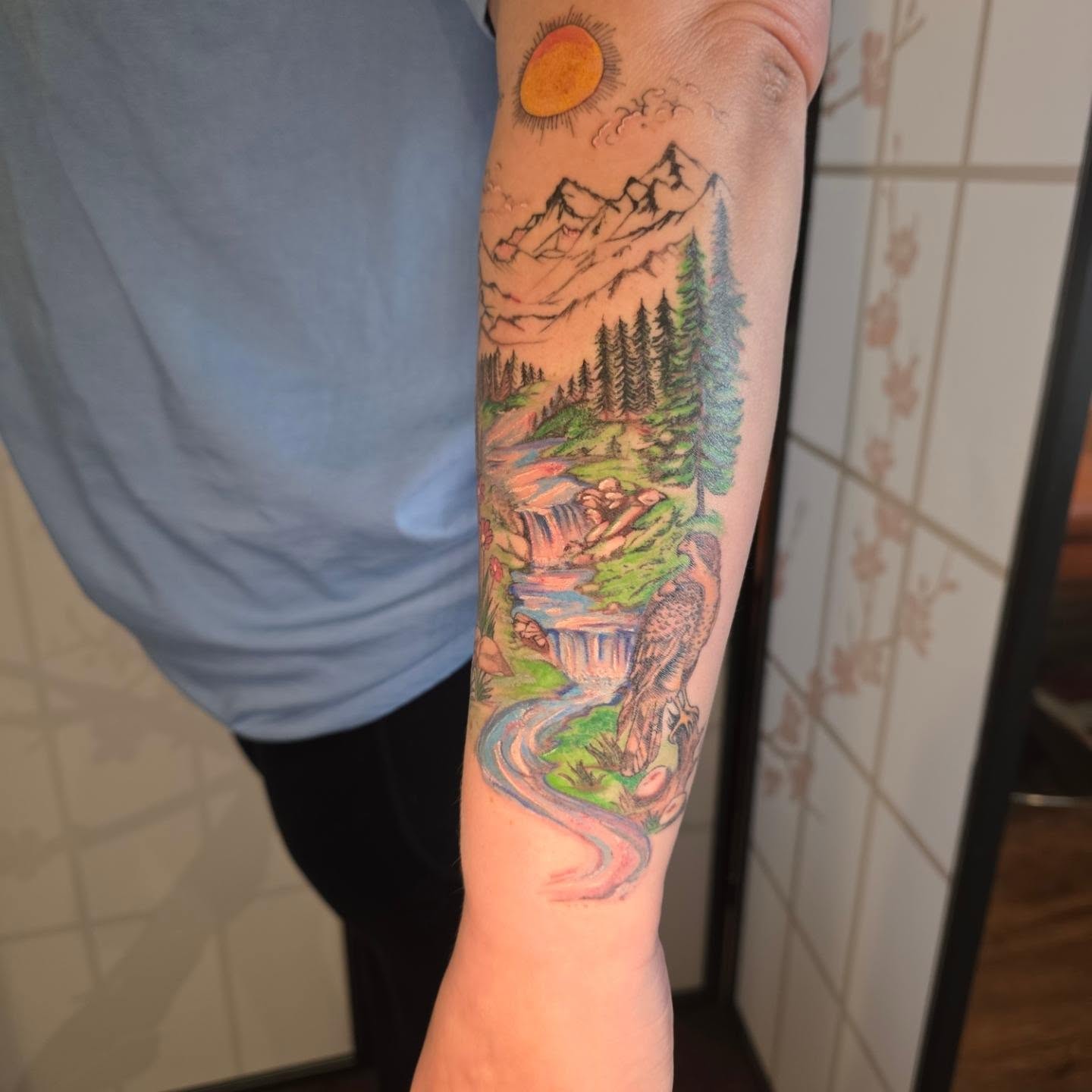Mountain landscape realism tattoo on the forearm by Maggie