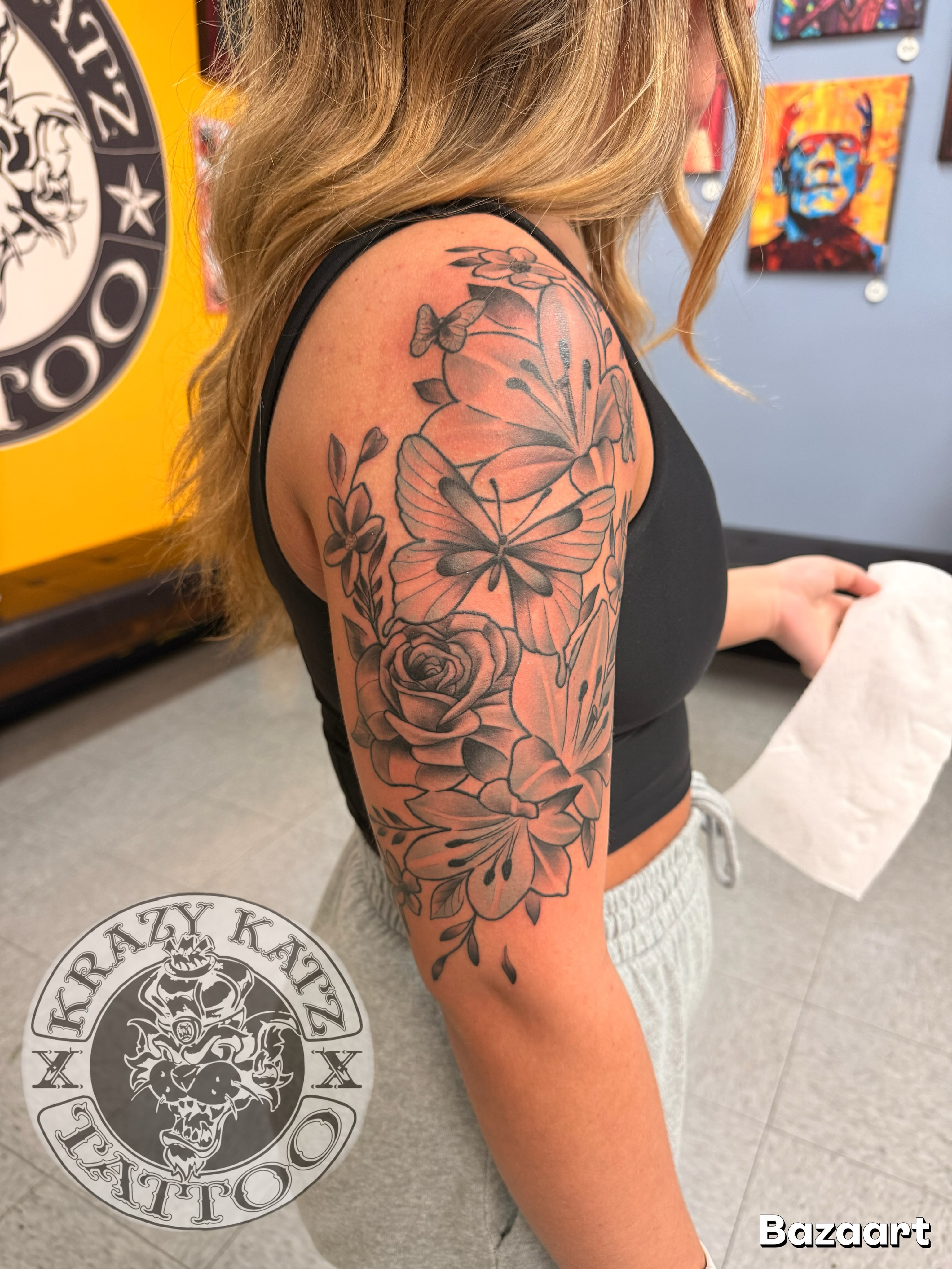 Floral arrangement black and grey tattoo on the upper arm by Frank Gomez 🎨