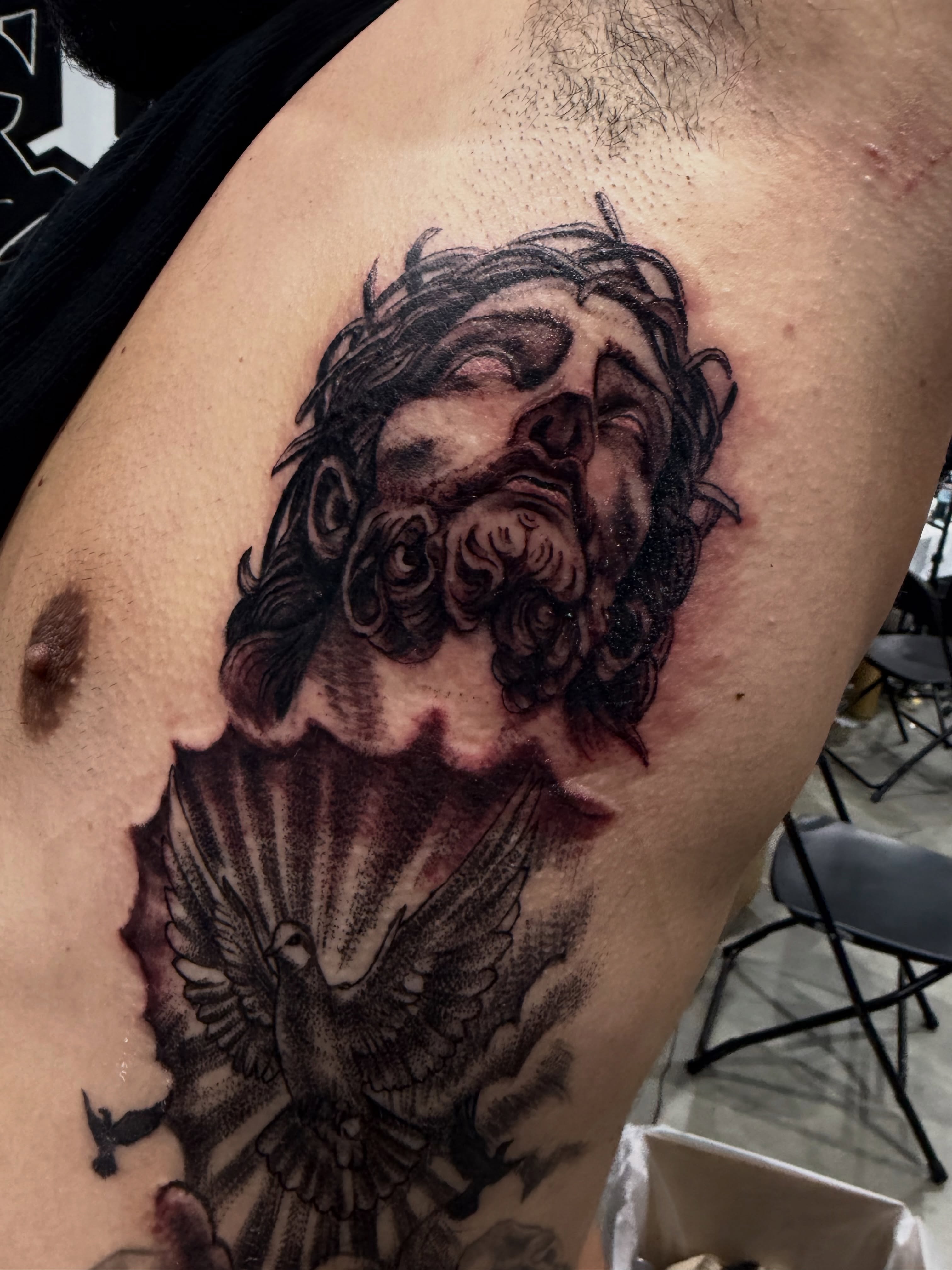 Religious figure with dove realism tattoo on the shoulder by Christa Martinez