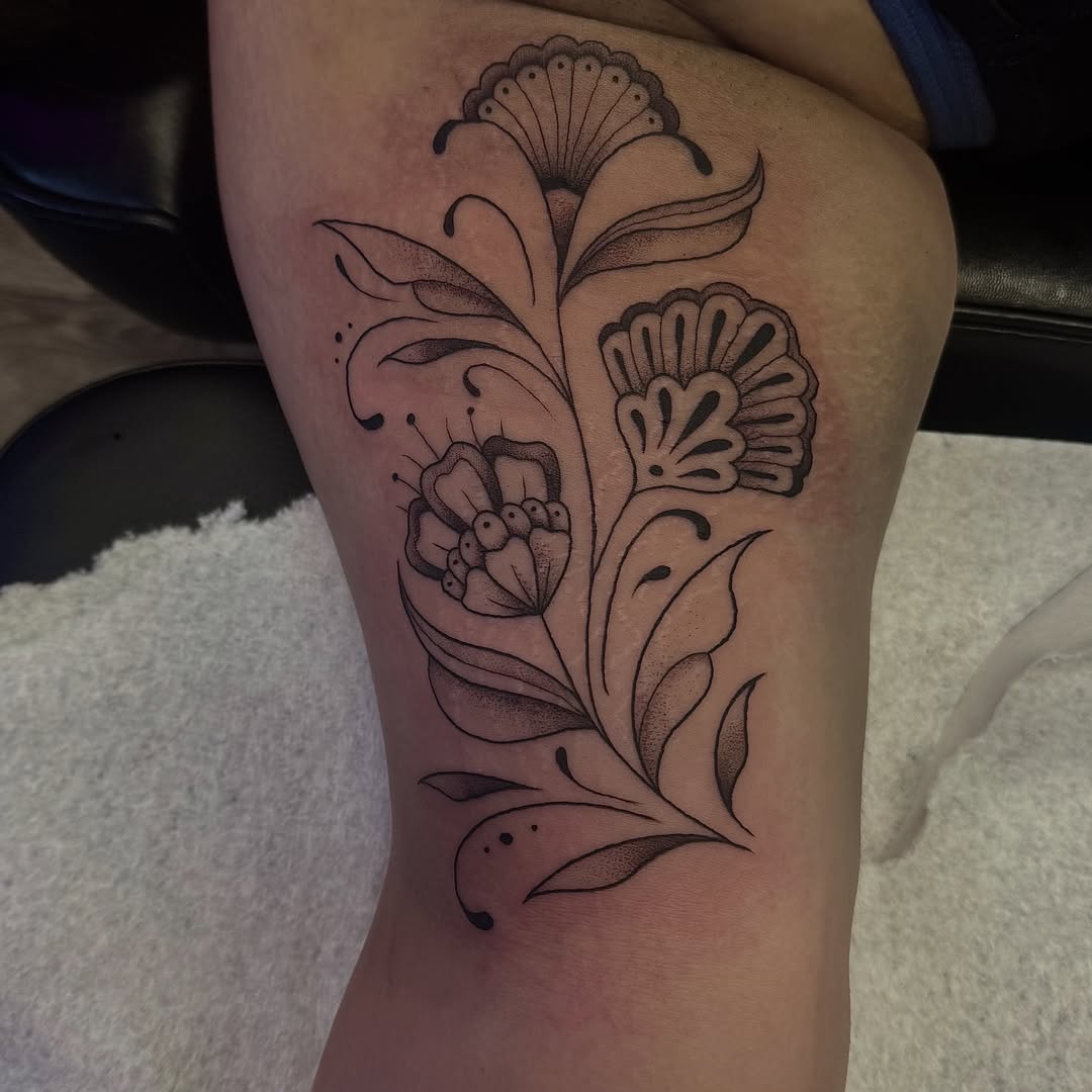 Floral design dotwork tattoo on the thigh by Kat Bennett