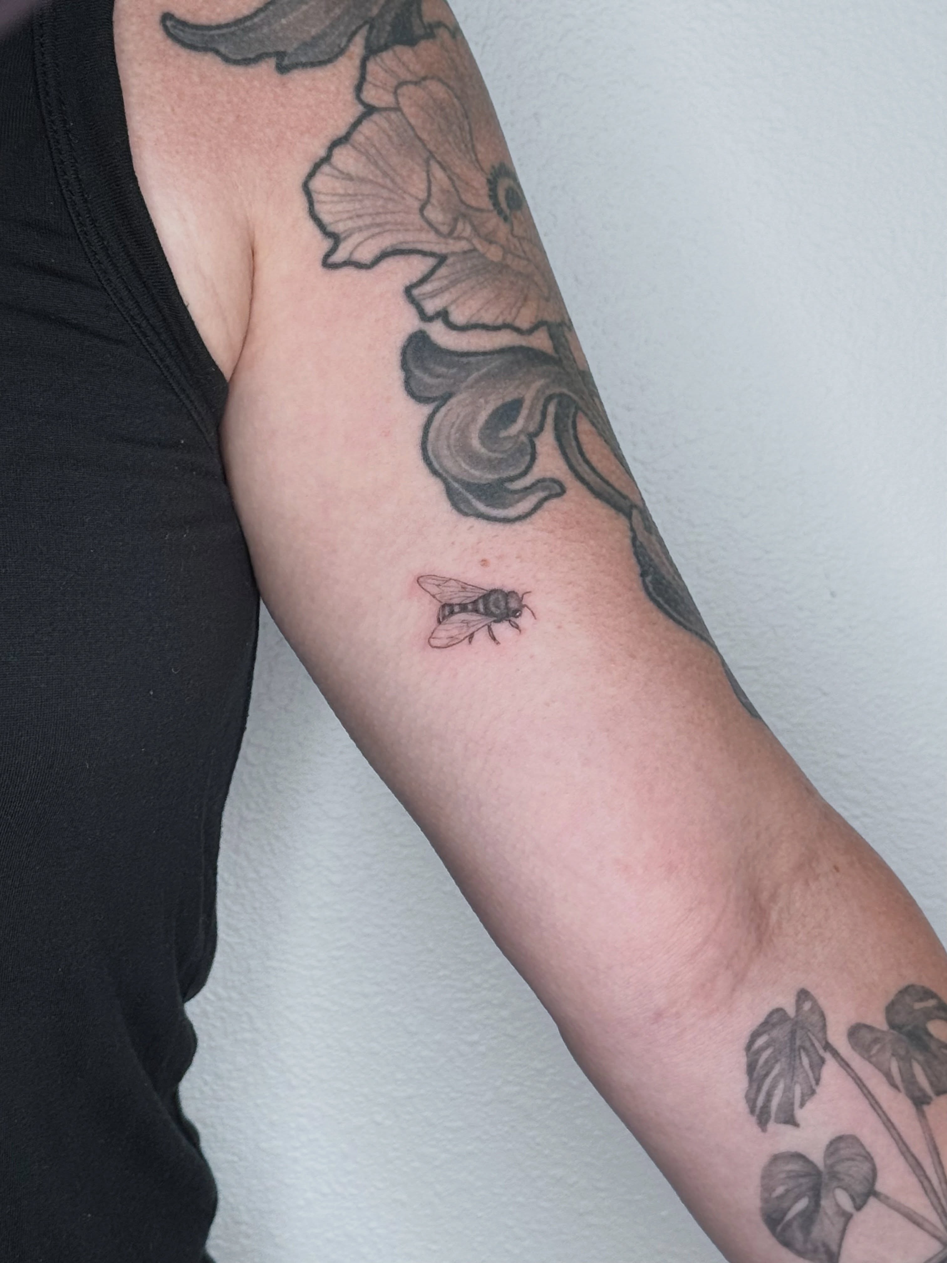 Bee black and grey tattoo on the forearm by Ashley Limon