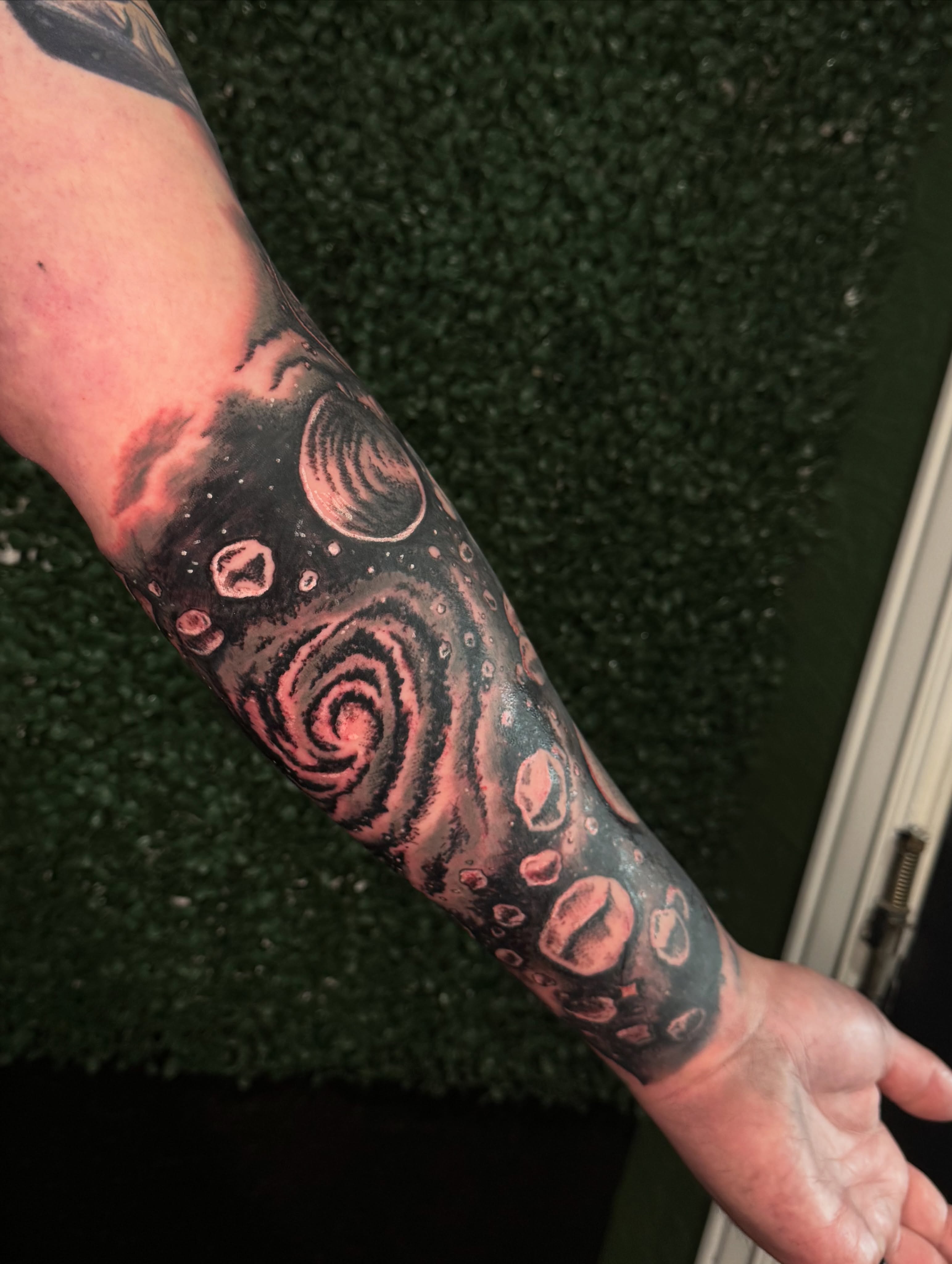 Galaxy dotwork tattoo on the forearm by Breanna Werner