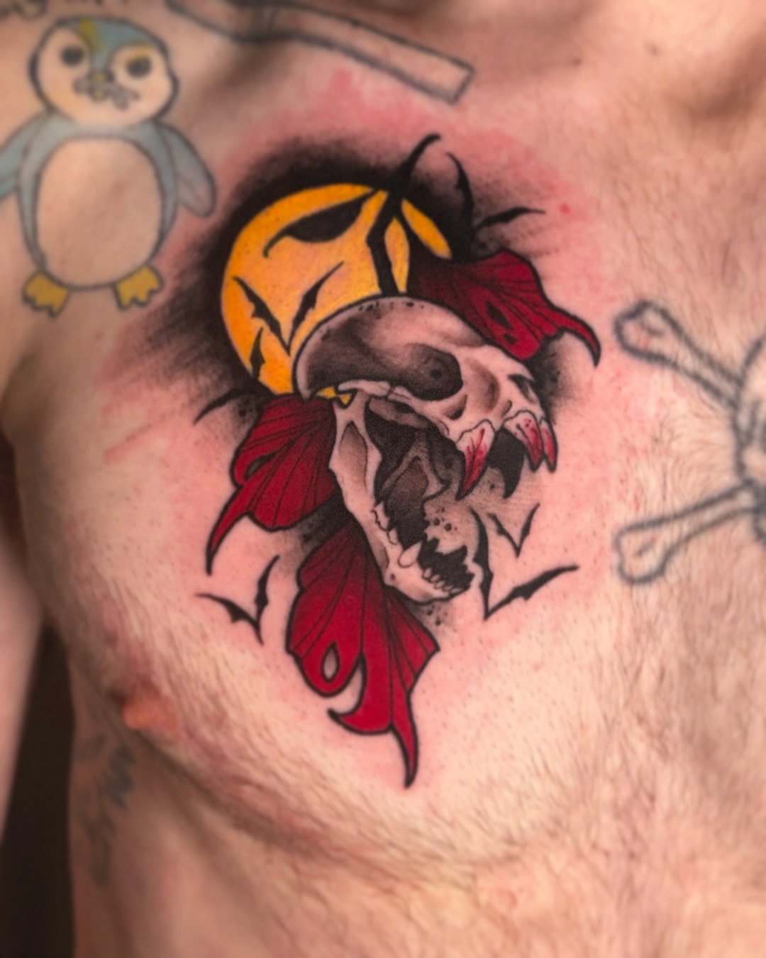 Skull with rose American traditional tattoo on the chest by Riley Borne