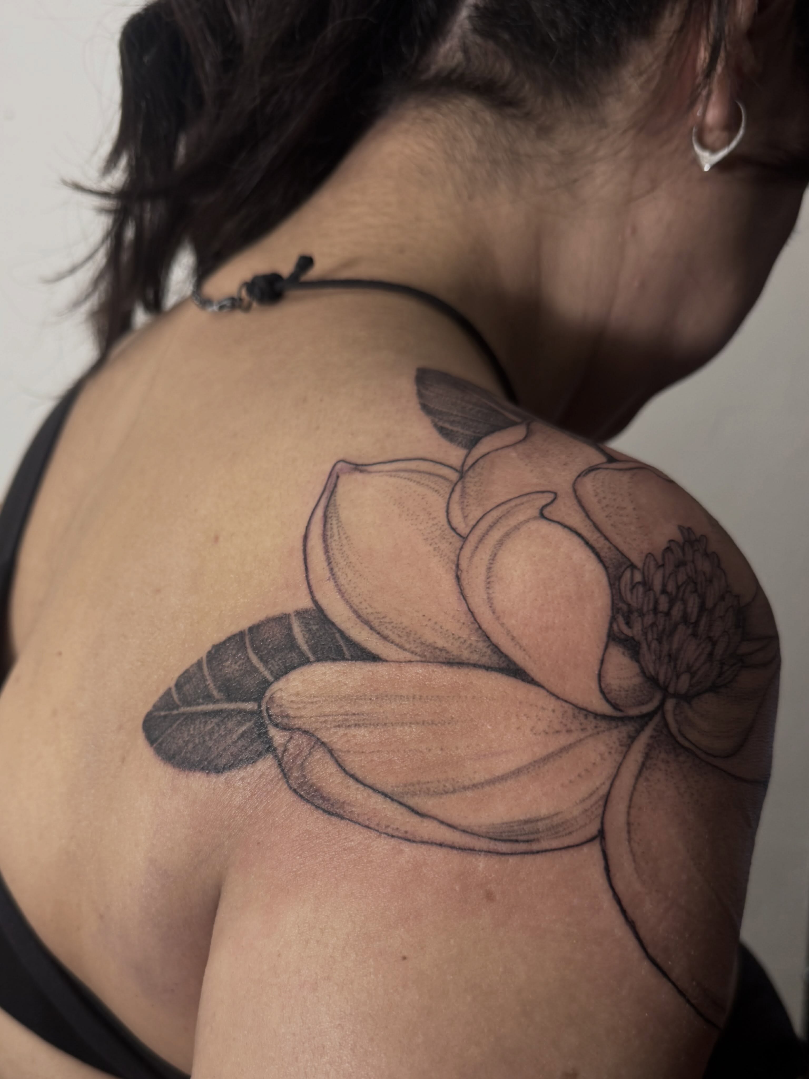 Lotus flower dotwork tattoo on the shoulder by Tianna Osborne