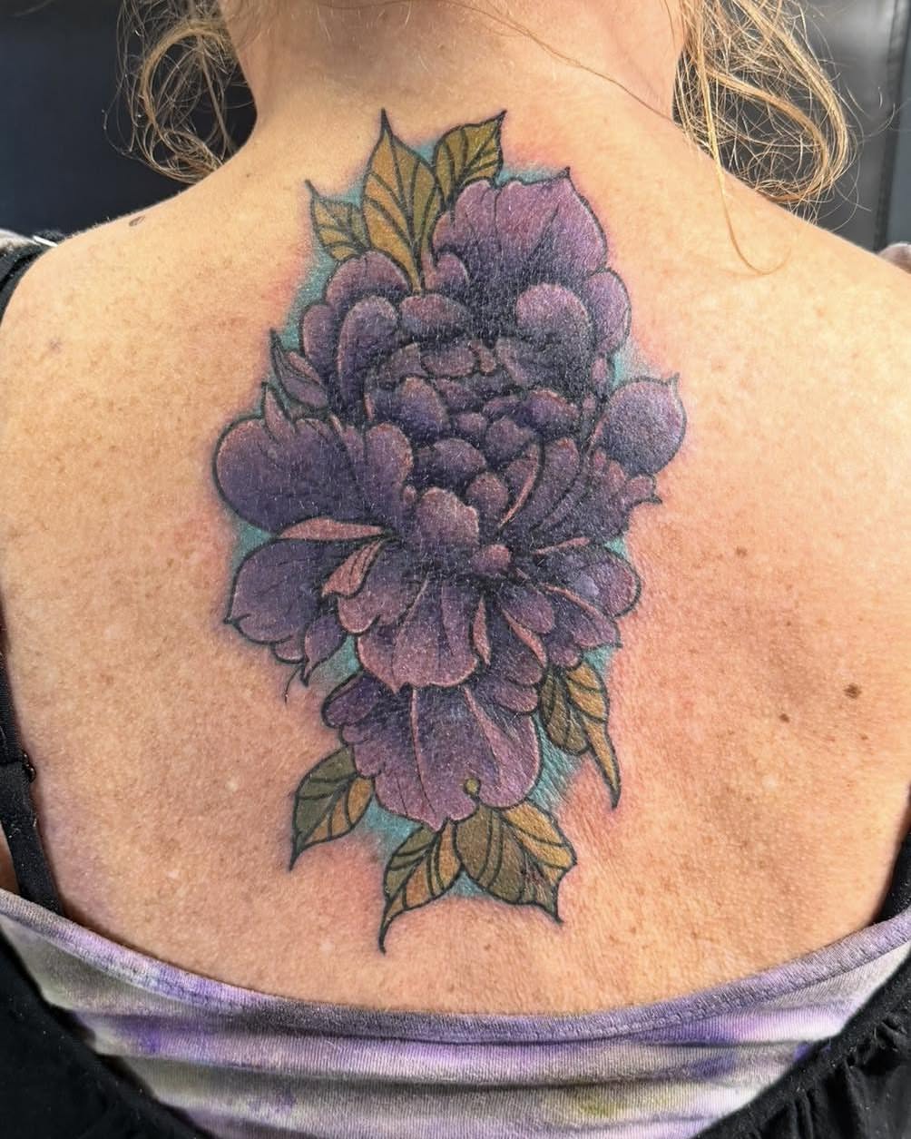 Purple flower new school tattoo on the back by Bryon Smith