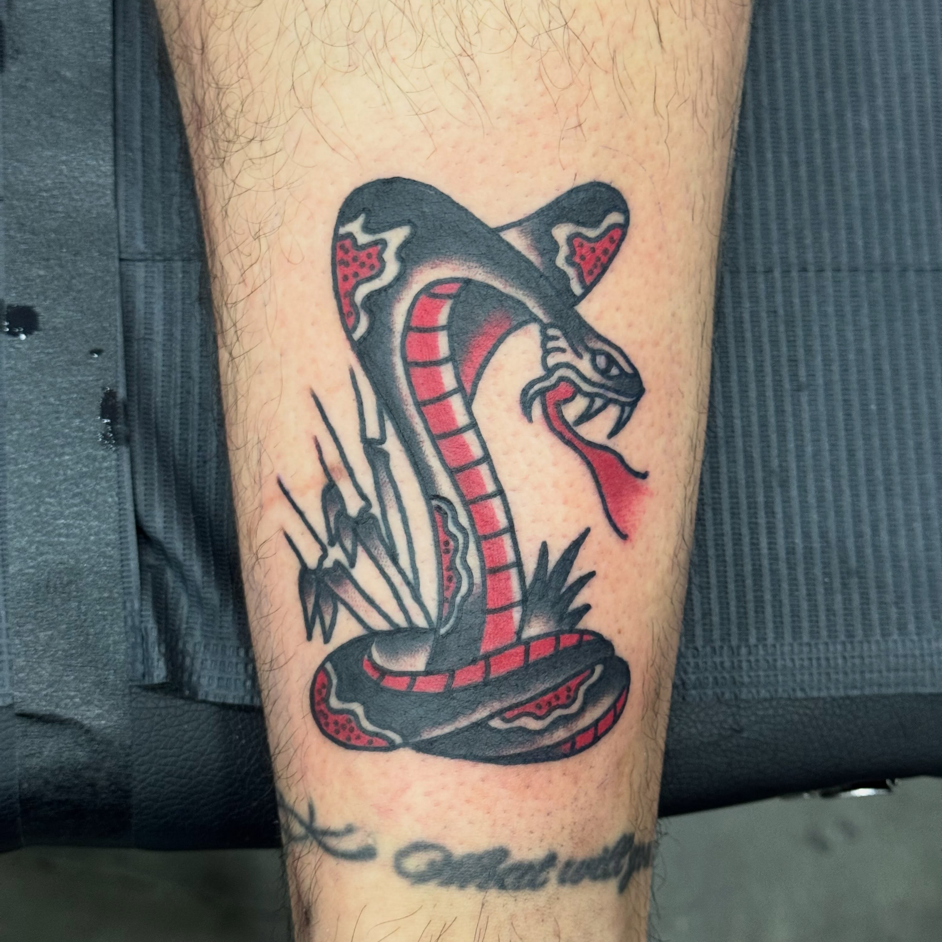 Snake American traditional tattoo on the forearm by Jack Hatchet Tattoos