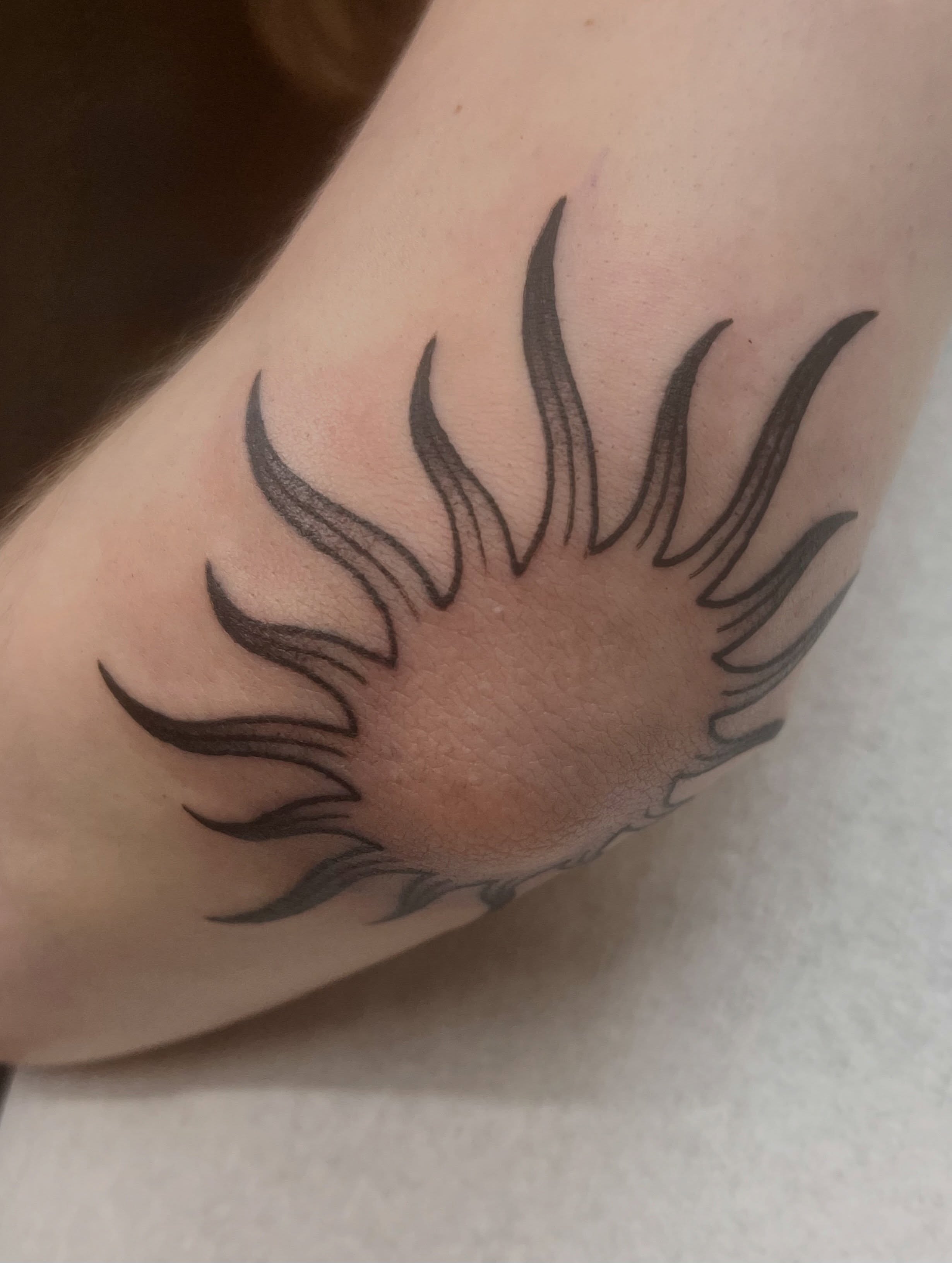 Sunburst black and grey tattoo on the forearm by jay
