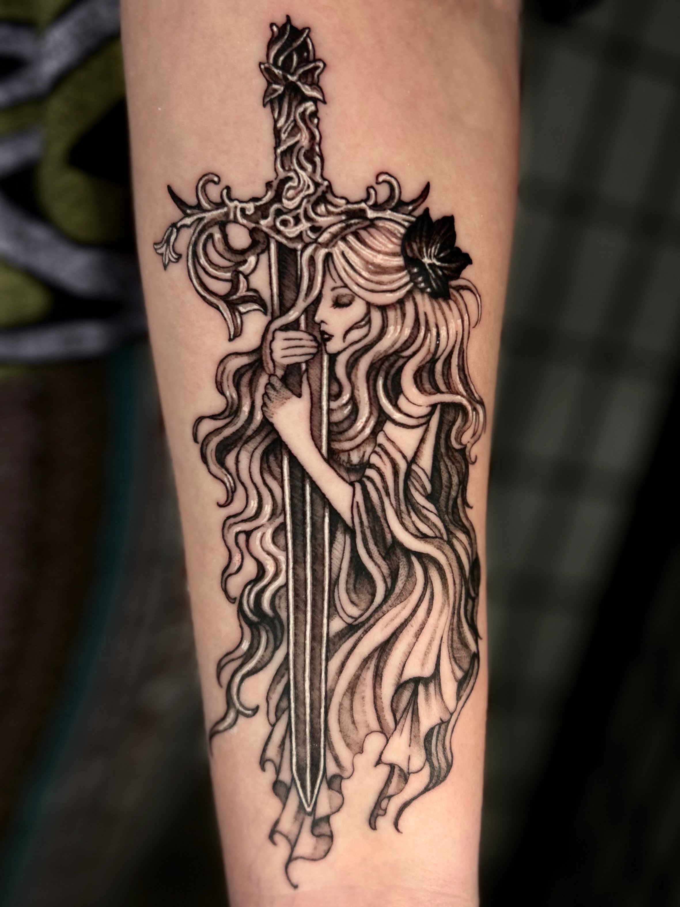 Sword and woman realism tattoo on the forearm by 𝔅𝔢𝔩𝔩𝔞