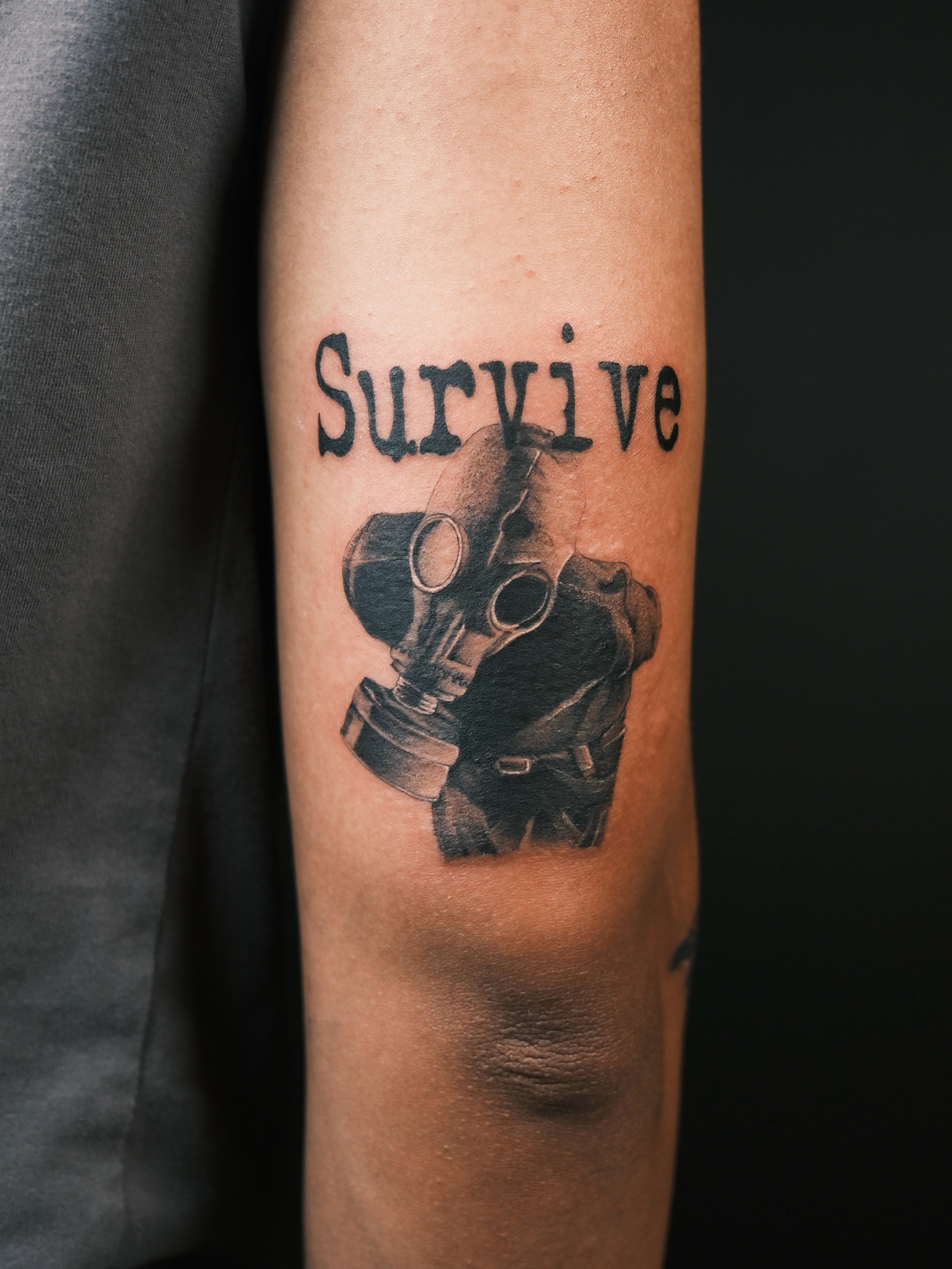 Gas mask black and grey tattoo on the forearm by Vu Nguyen