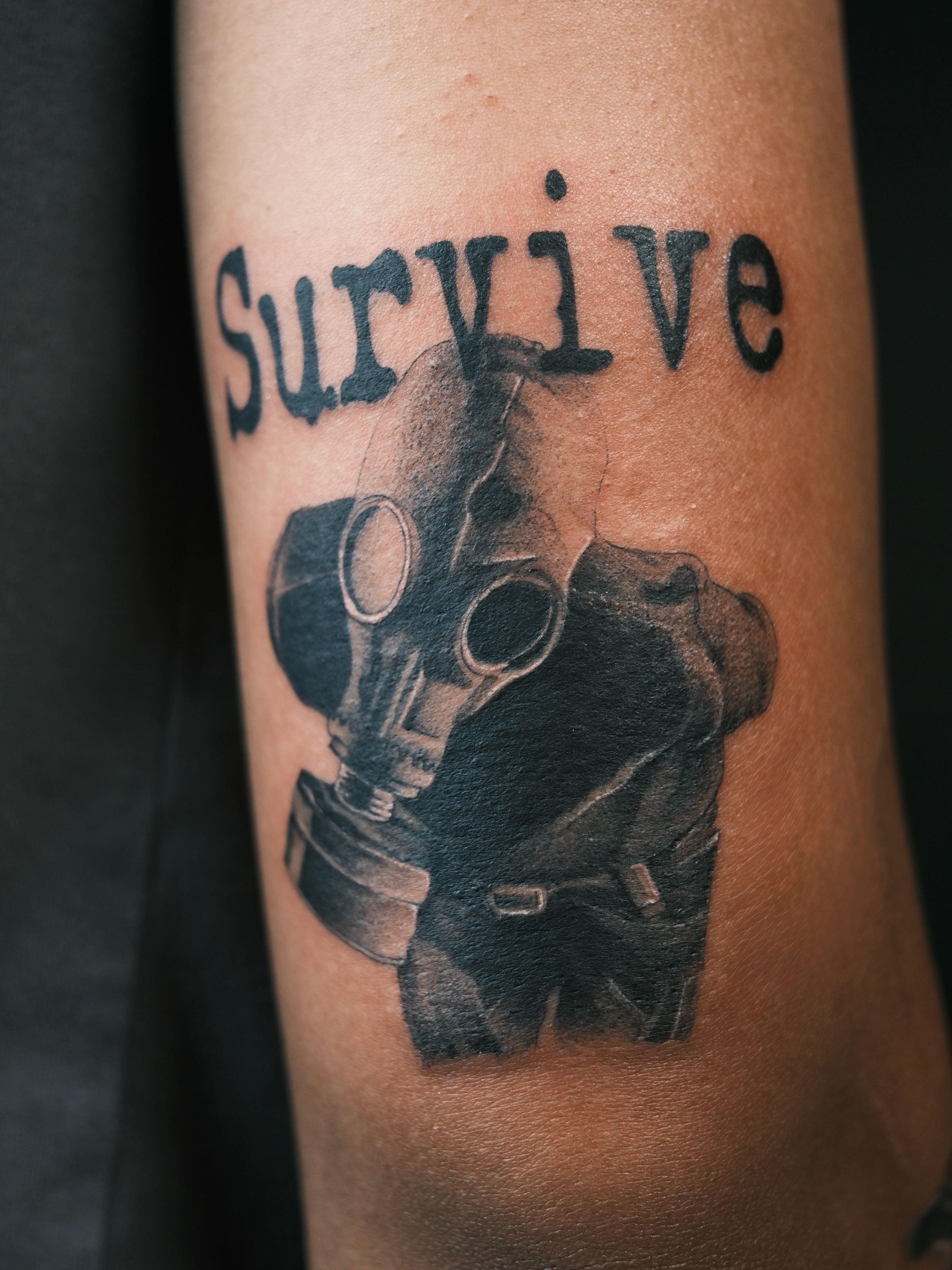 Gas mask black and grey tattoo on the forearm by Vu Nguyen