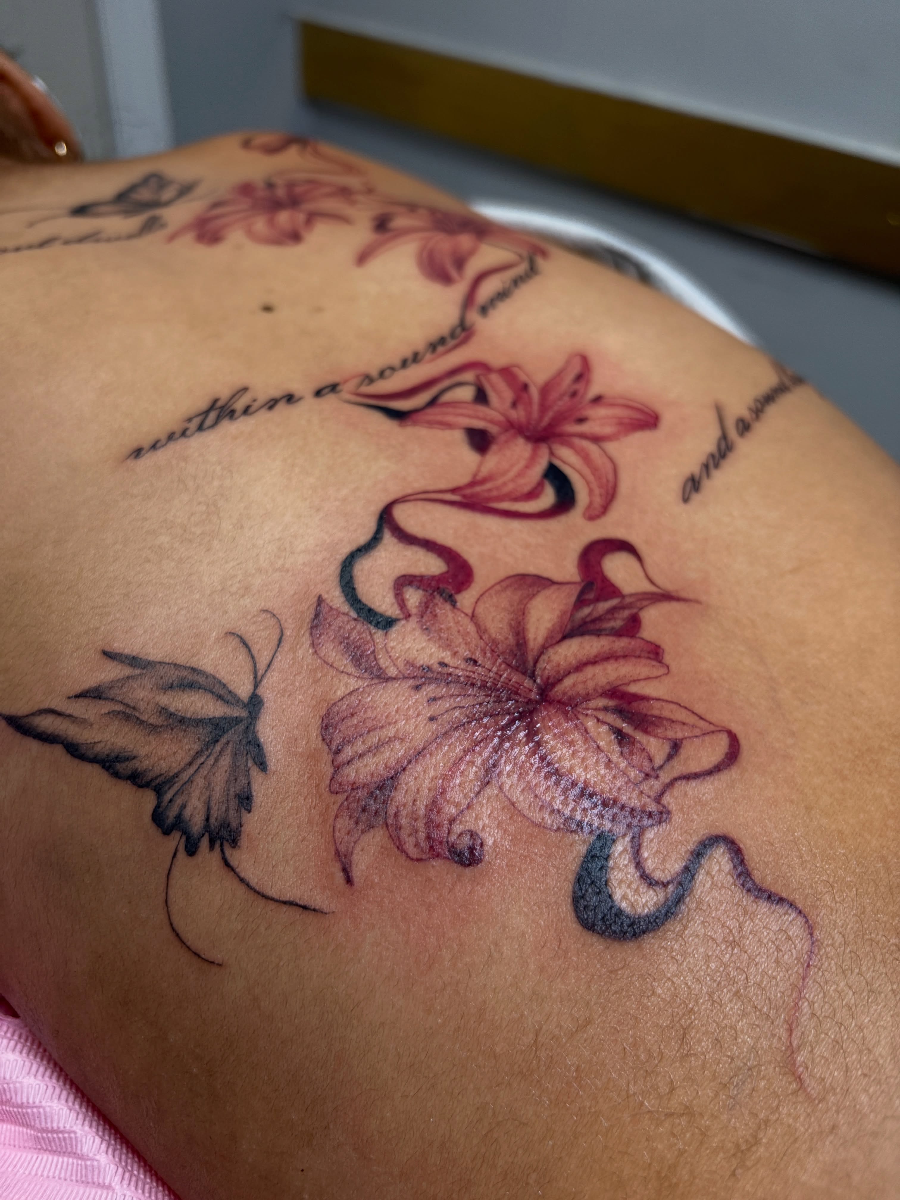 Flowers and butterfly new school tattoo on the back by Destineé