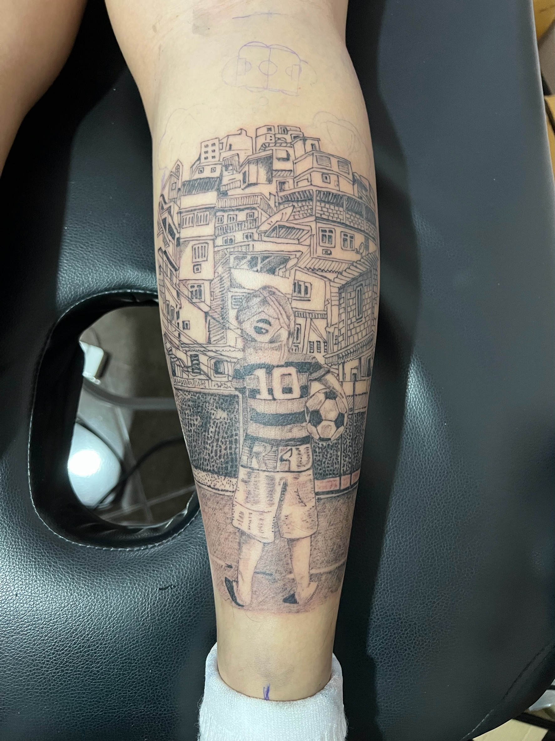 Soccer player and favela realism tattoo on the forearm by Ink Napawong