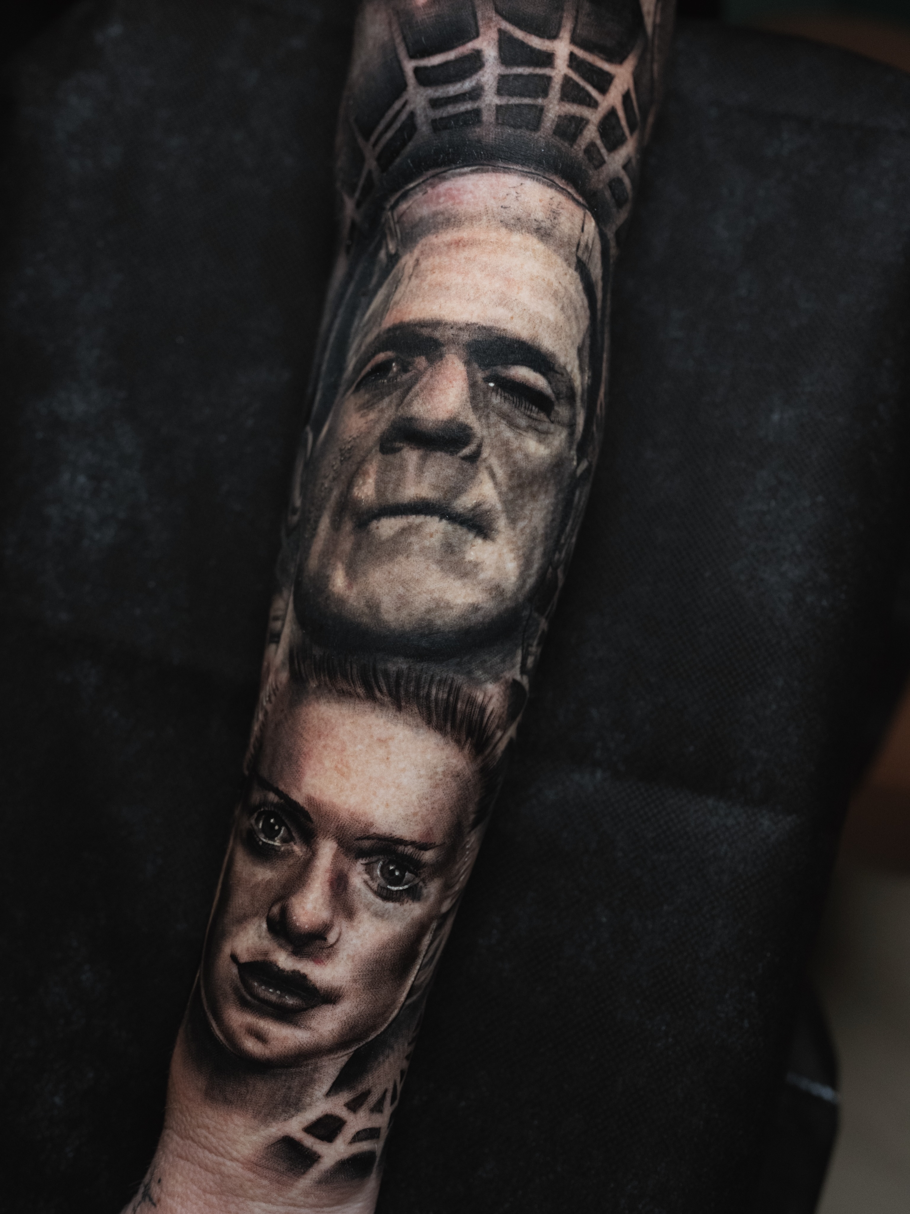 Frankenstein and woman realism tattoo on the forearm by Robert Graye