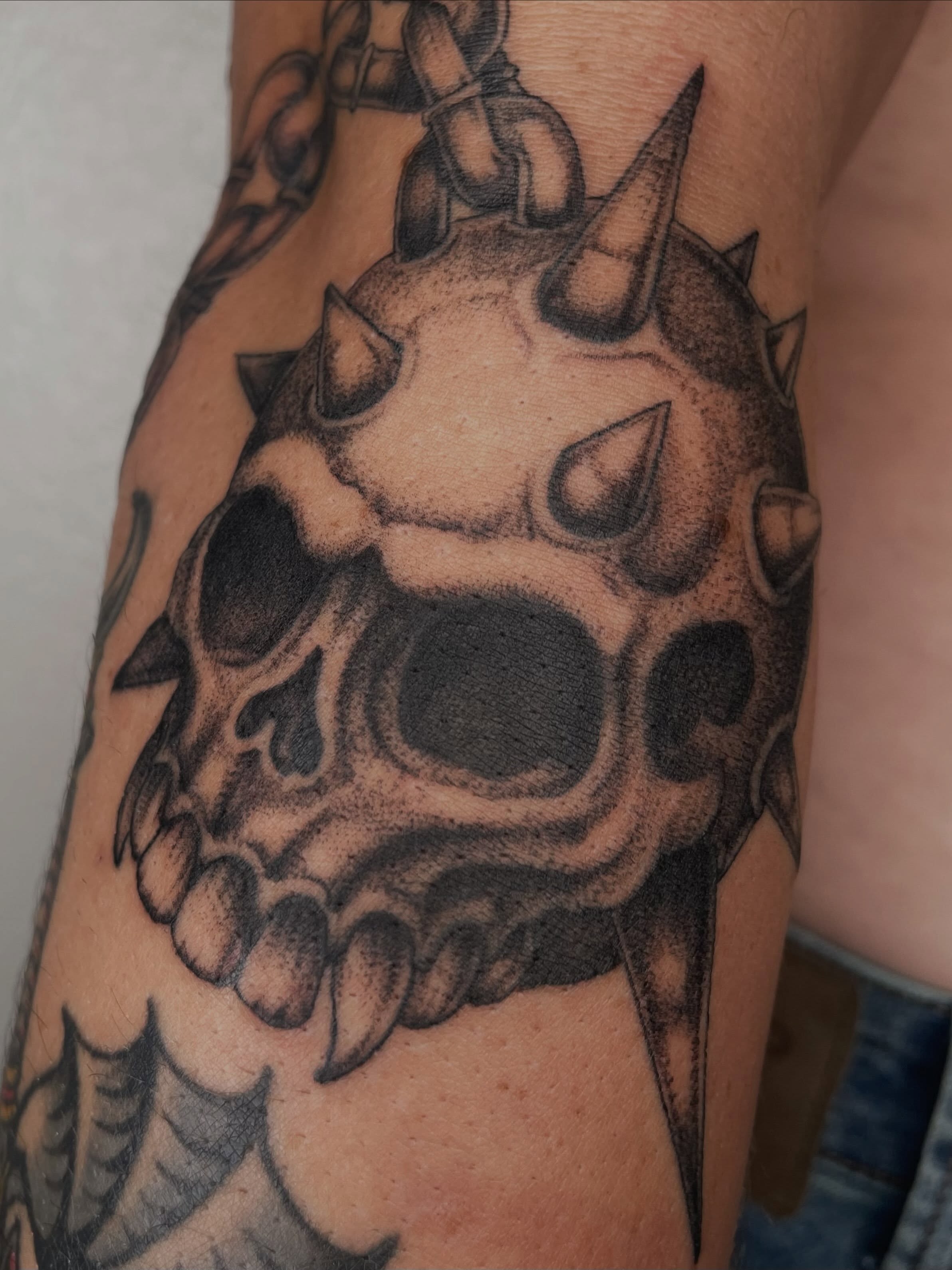 Skull with spikes dotwork tattoo on the forearm by Vash
