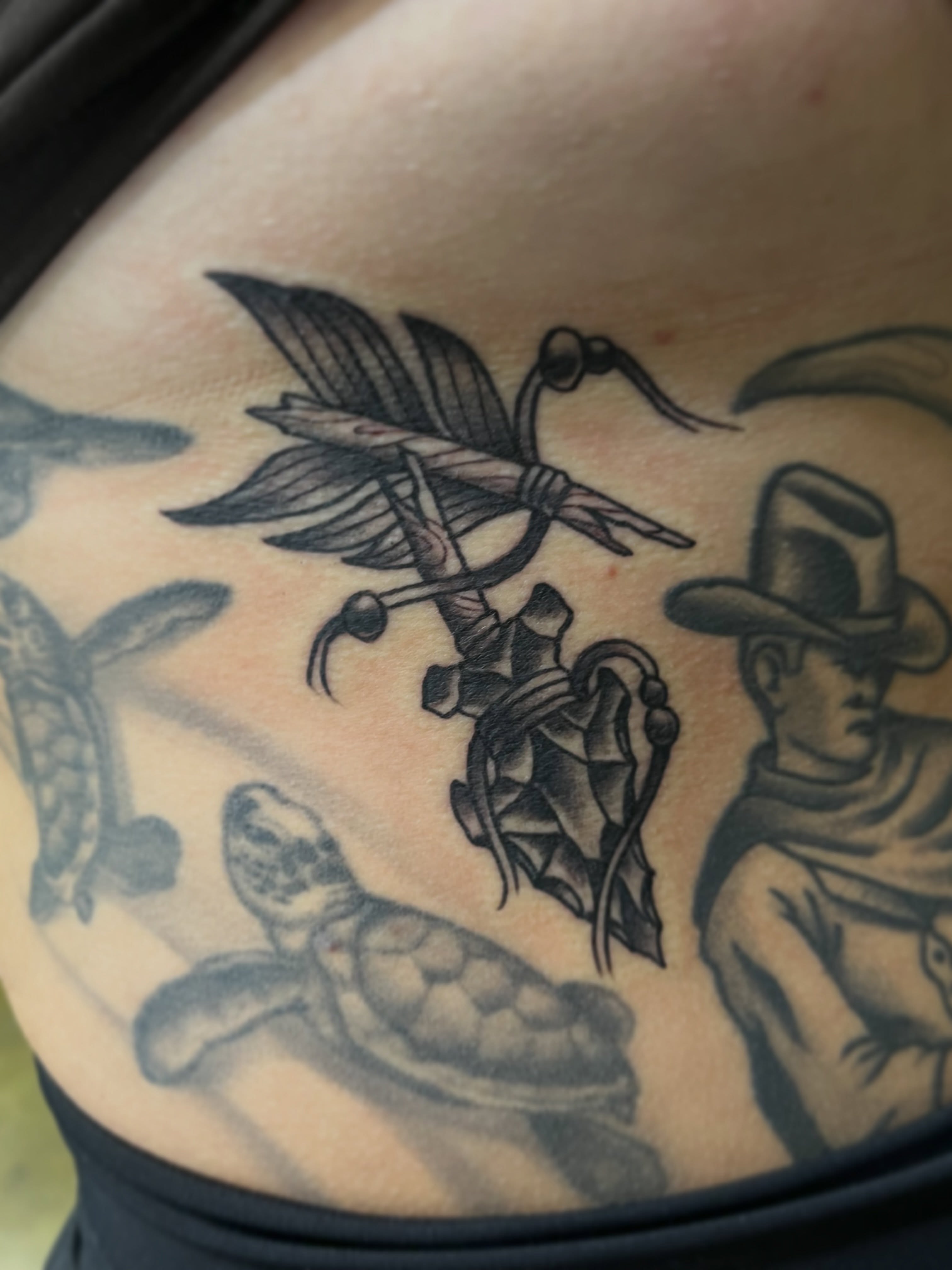 Bird and feather black and grey tattoo on the thigh by Evan Perrine