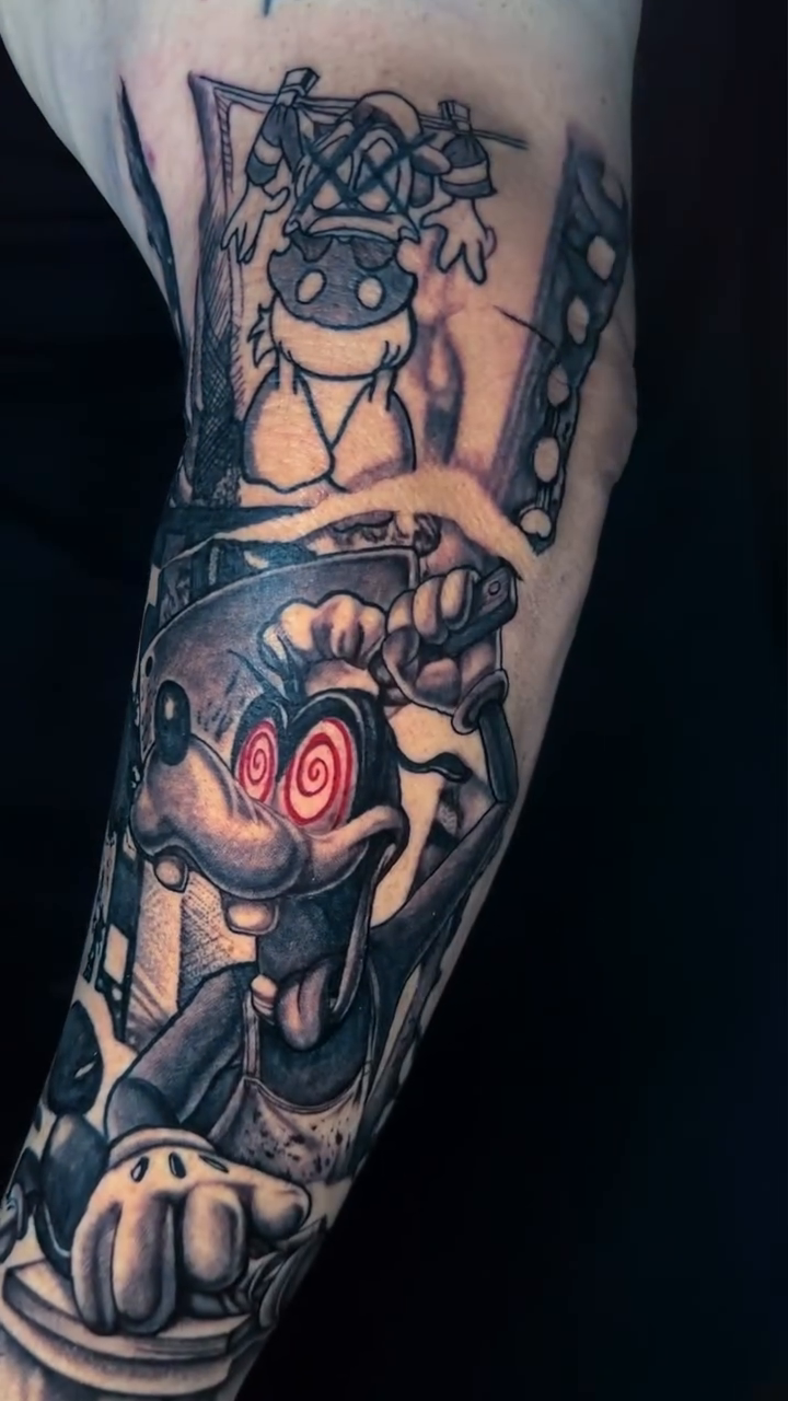 Goofy character with red eyes realism tattoo by Adrian Dominguez, Las Vegas, Nevada