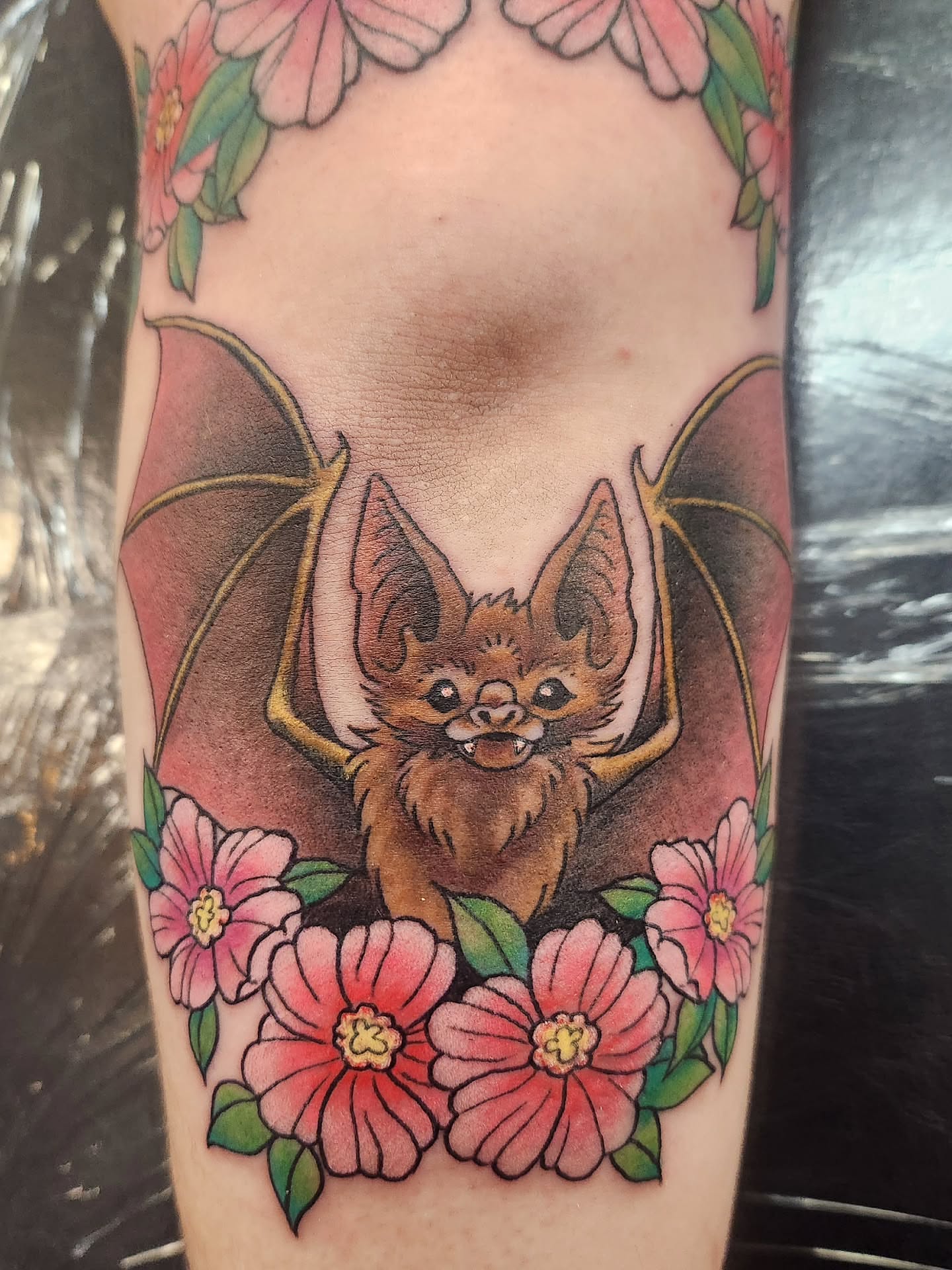 Bat and flowers realism tattoo on the forearm by Samantha Von Zombia, Saint Paul, Minnesota