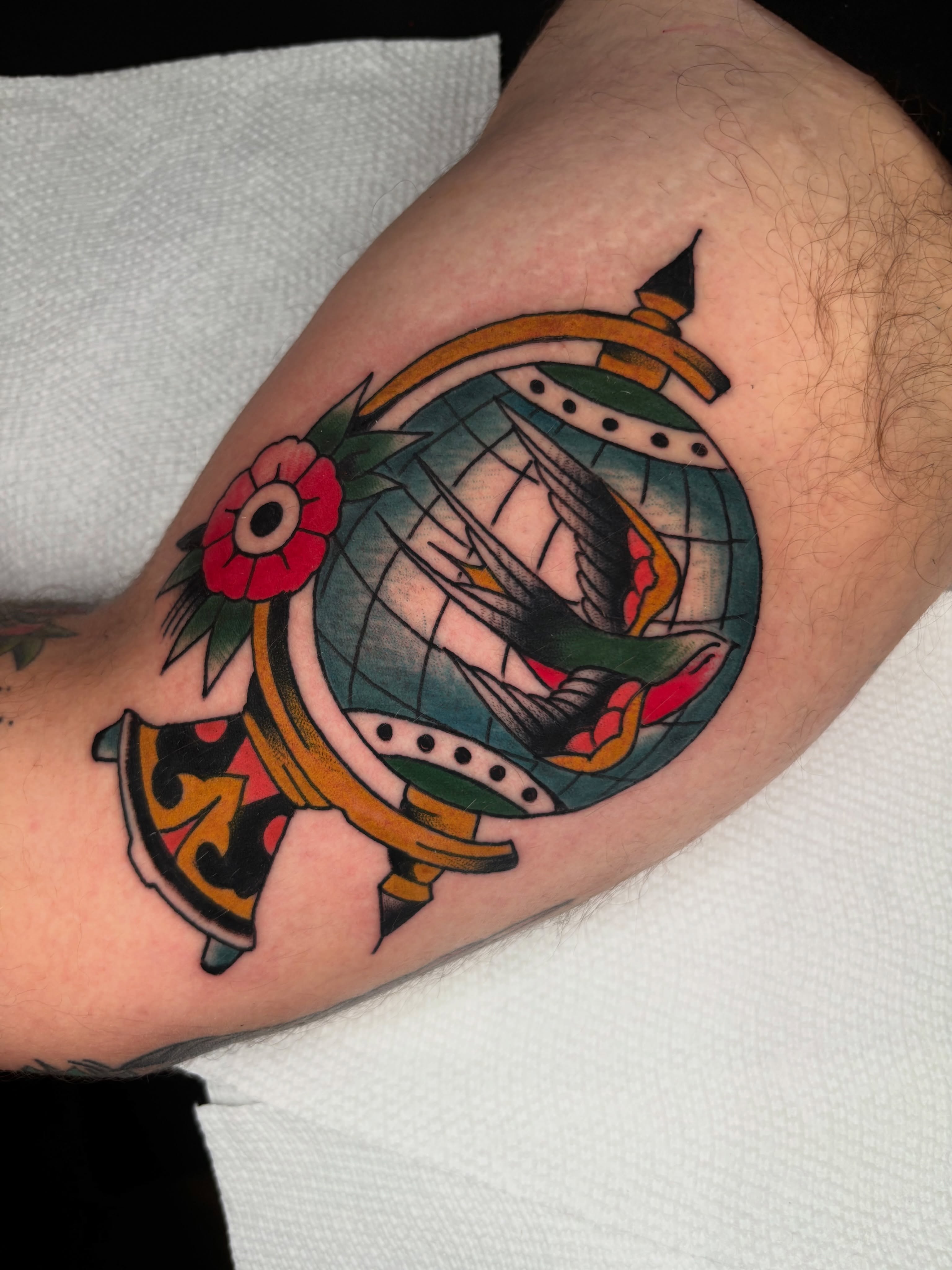 Bird and globe American traditional tattoo on the forearm by ericka bates