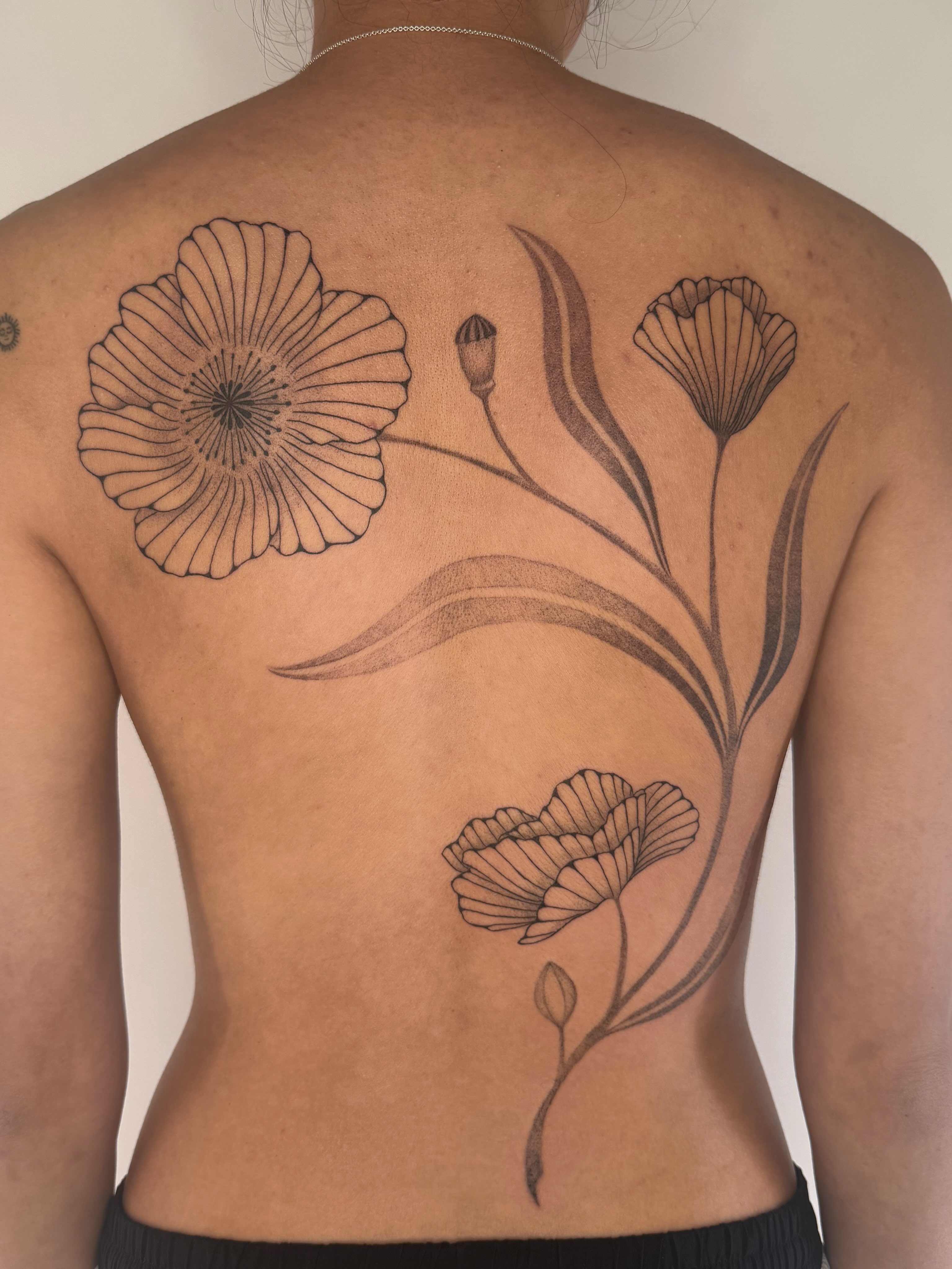 Flowers black and grey tattoo on the back by Leah Ramos