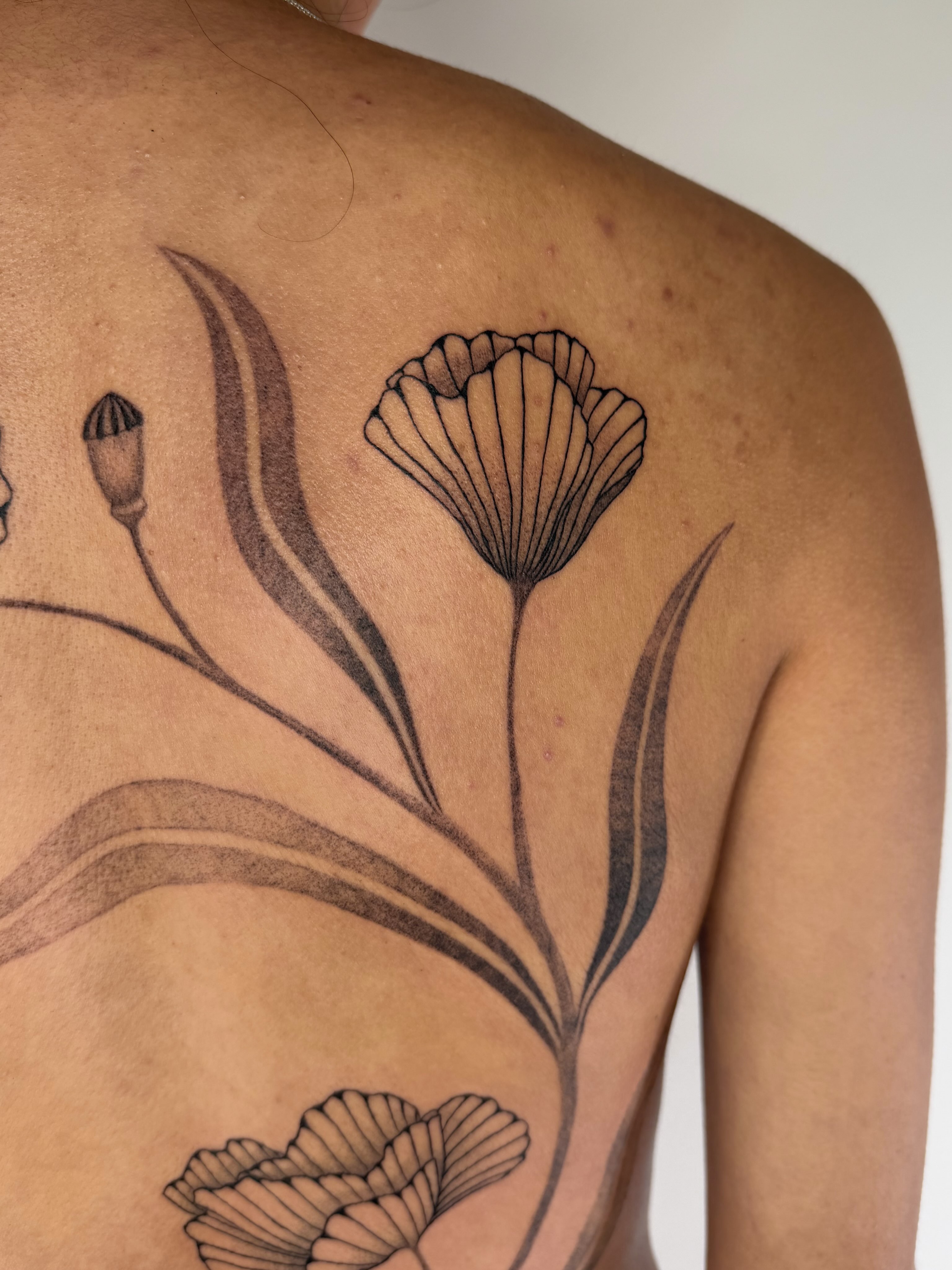 Flower black and grey tattoo on the back by Leah Ramos