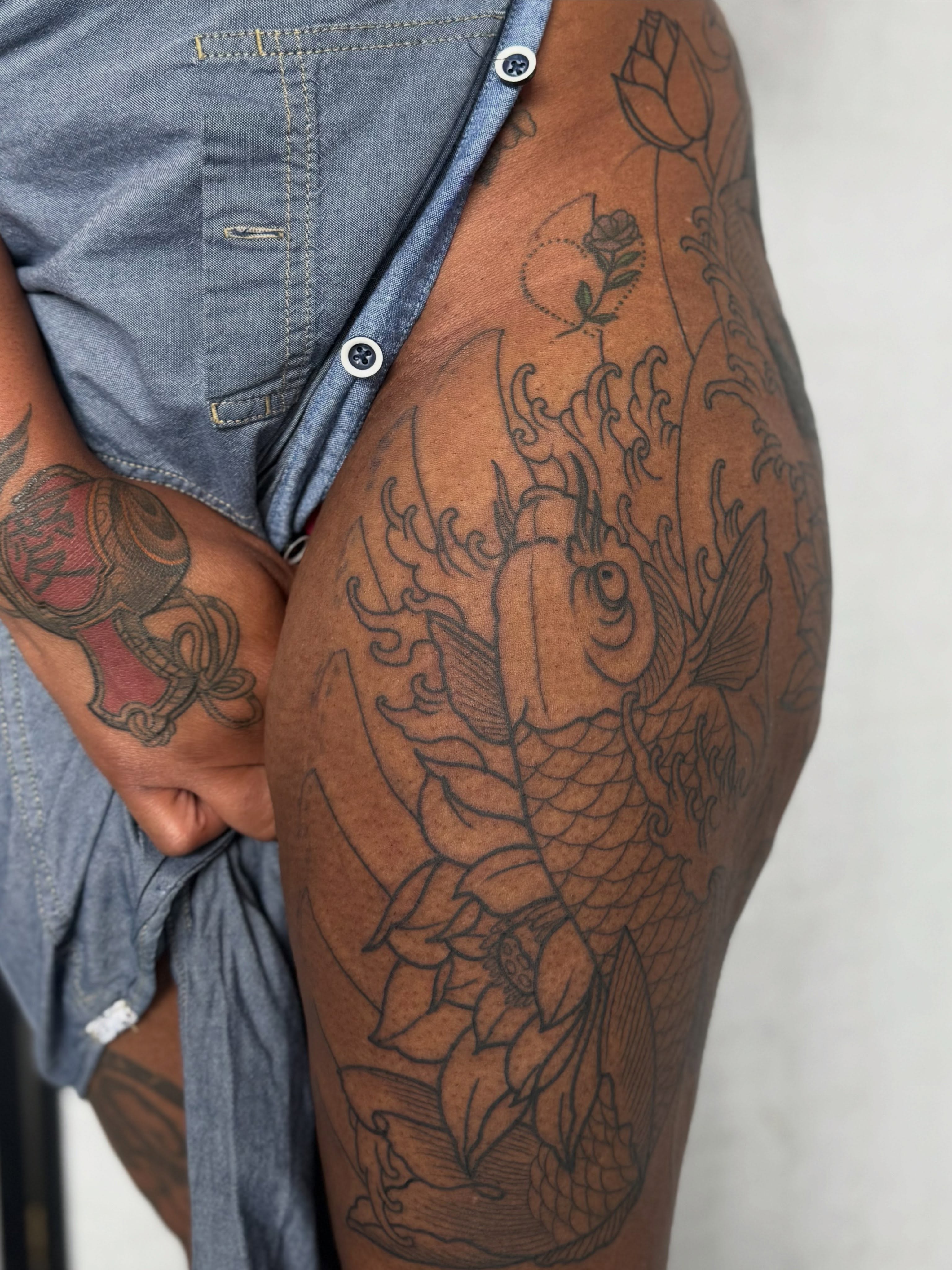 Koi fish and lotus black and grey tattoo on the thigh by Randall Croley El
