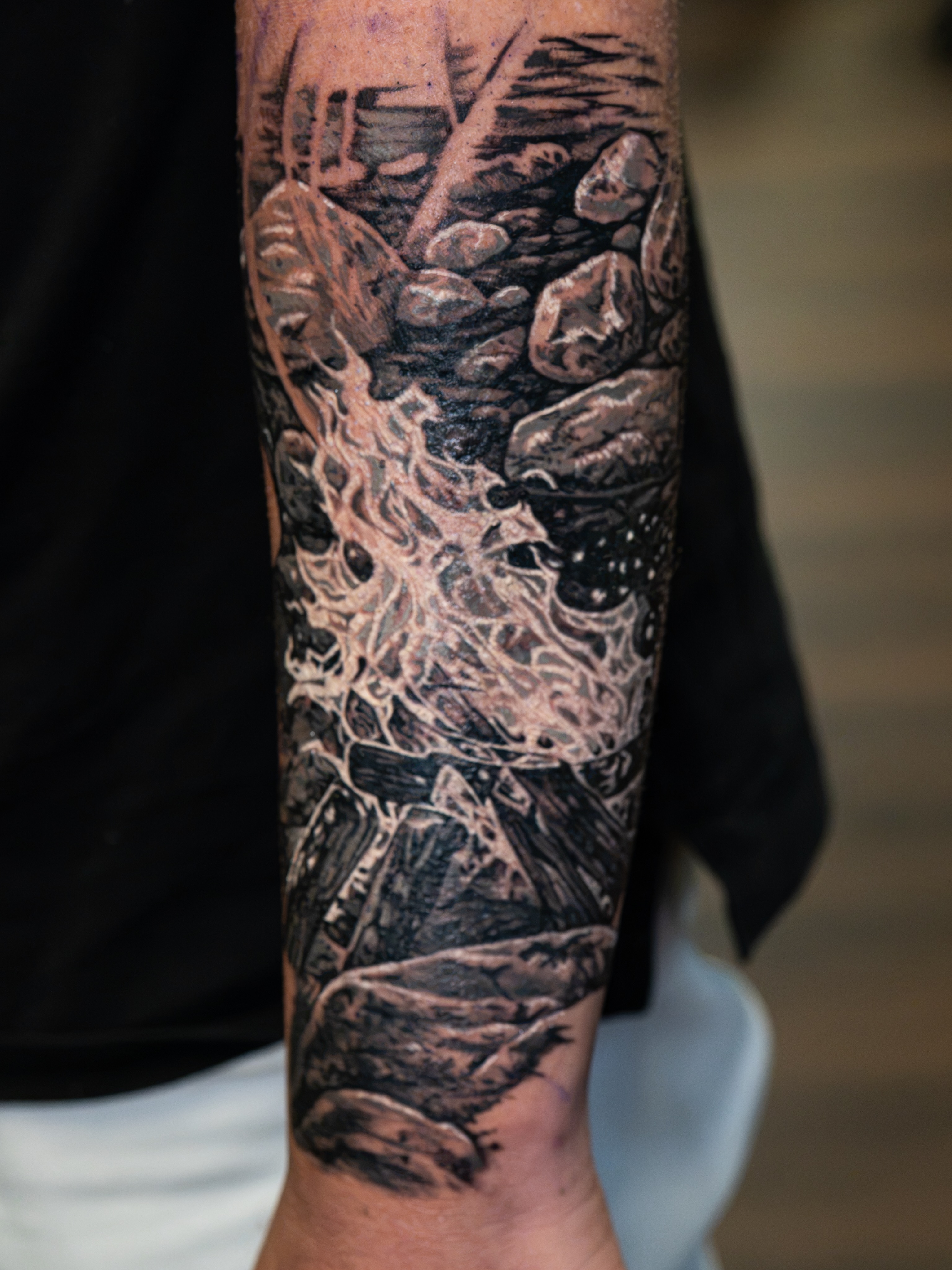 Rocks and water realism tattoo on the forearm by Simon Pouliot
