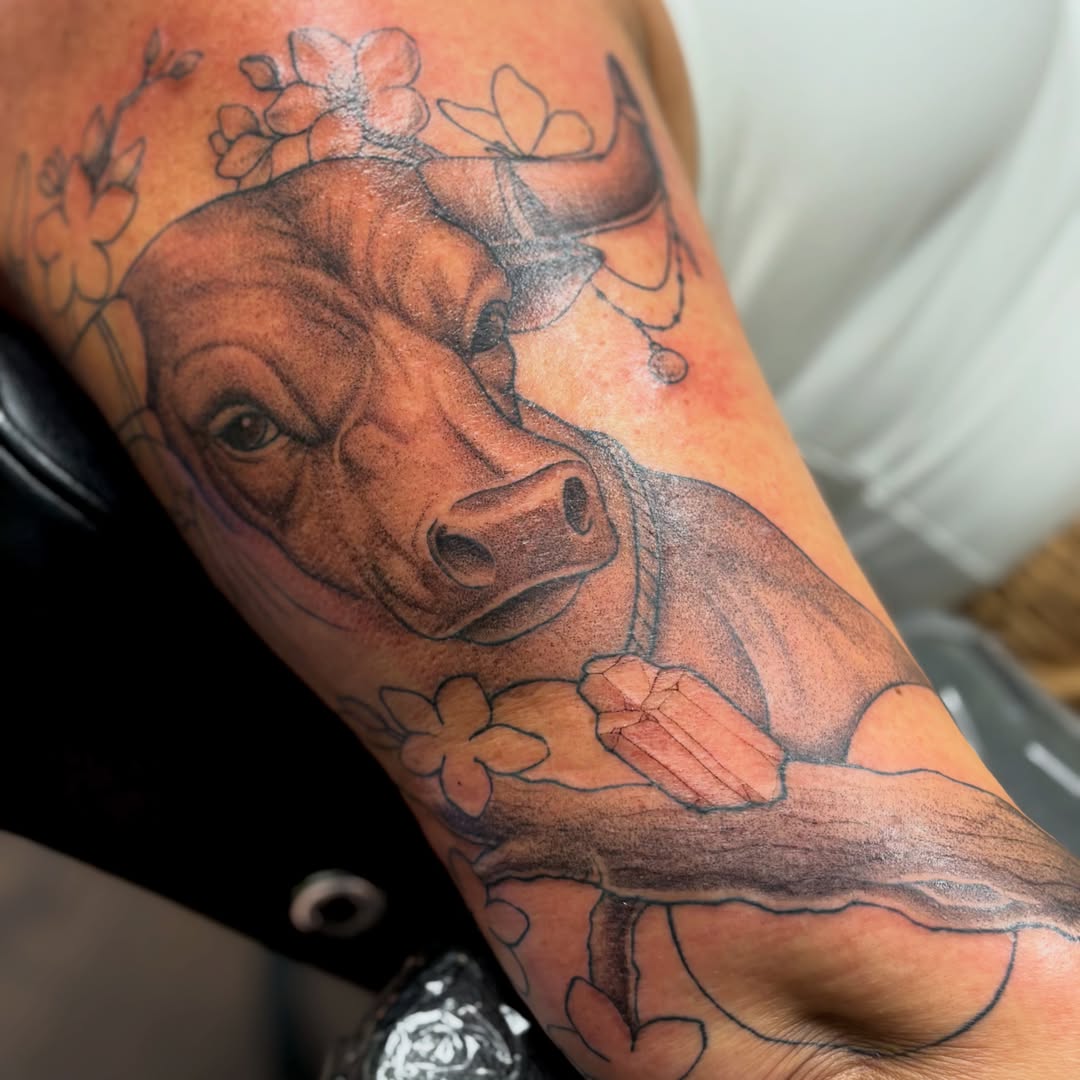 Pig and flowers realism tattoo on the forearm by sydney honn