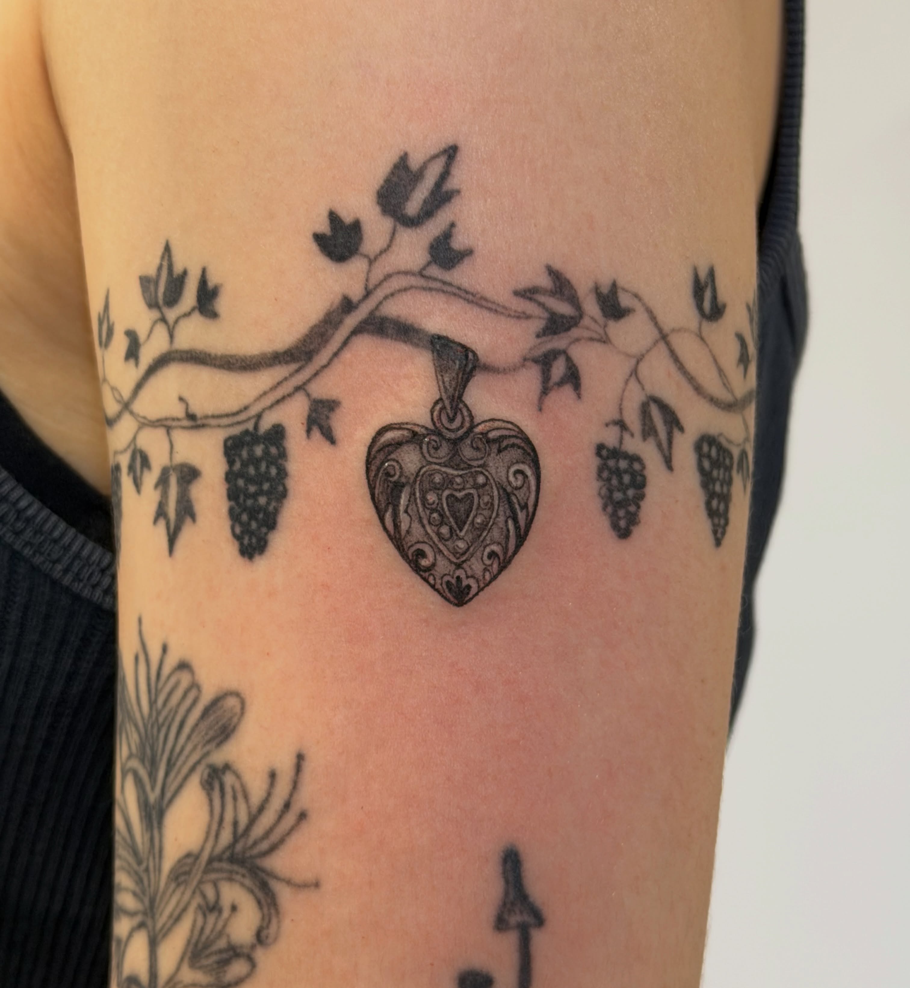 Heart with grapes black and grey tattoo on the forearm by Sienna (jj) Hicks