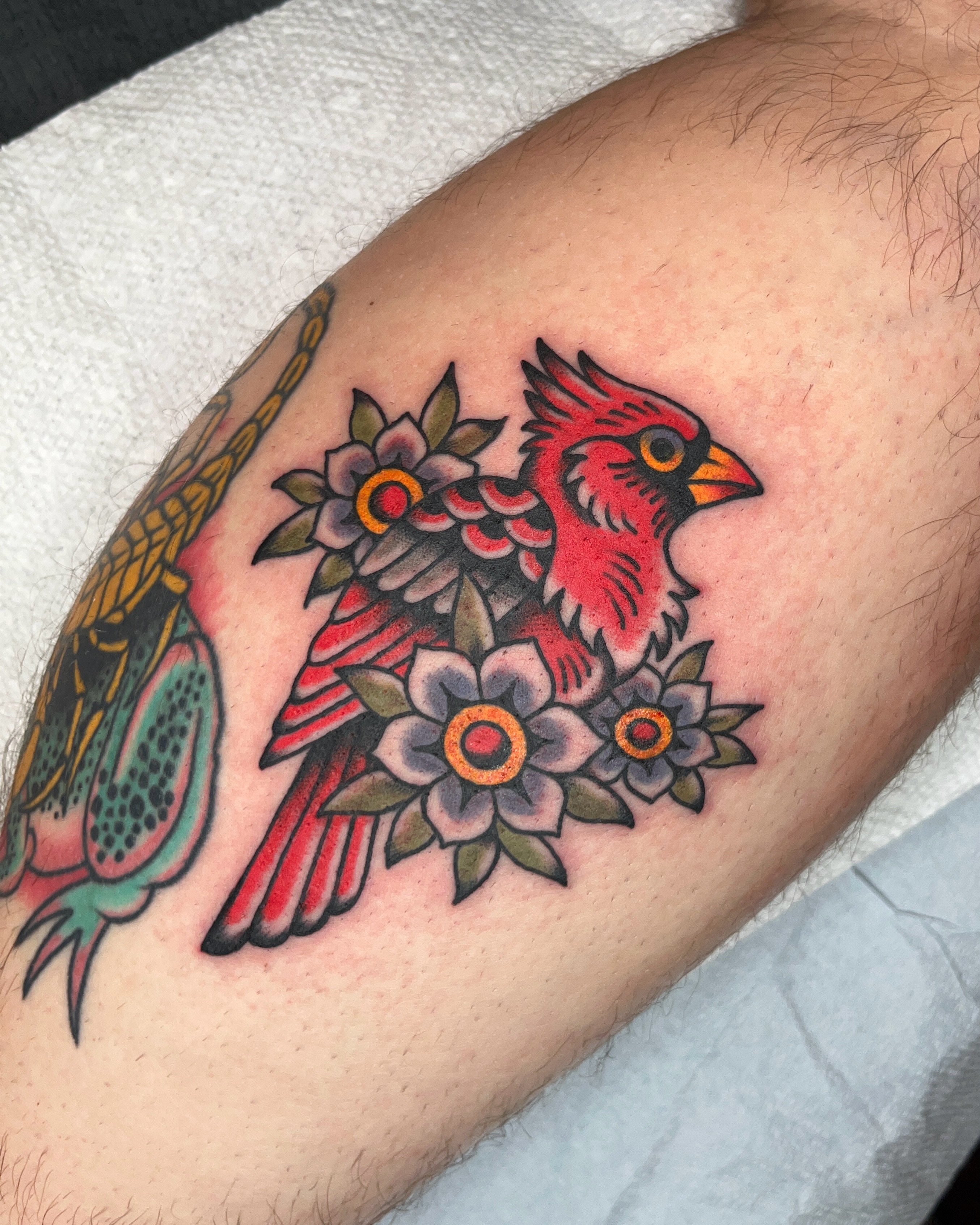 Cardinal and flowers American traditional tattoo on the forearm by Nat Power